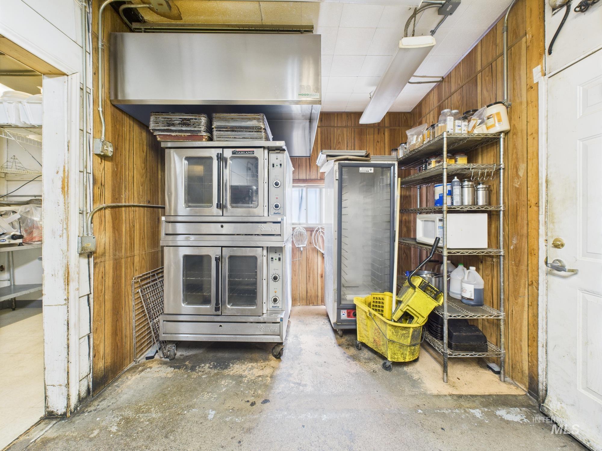 Kitchen with concrete floors and wood walls
