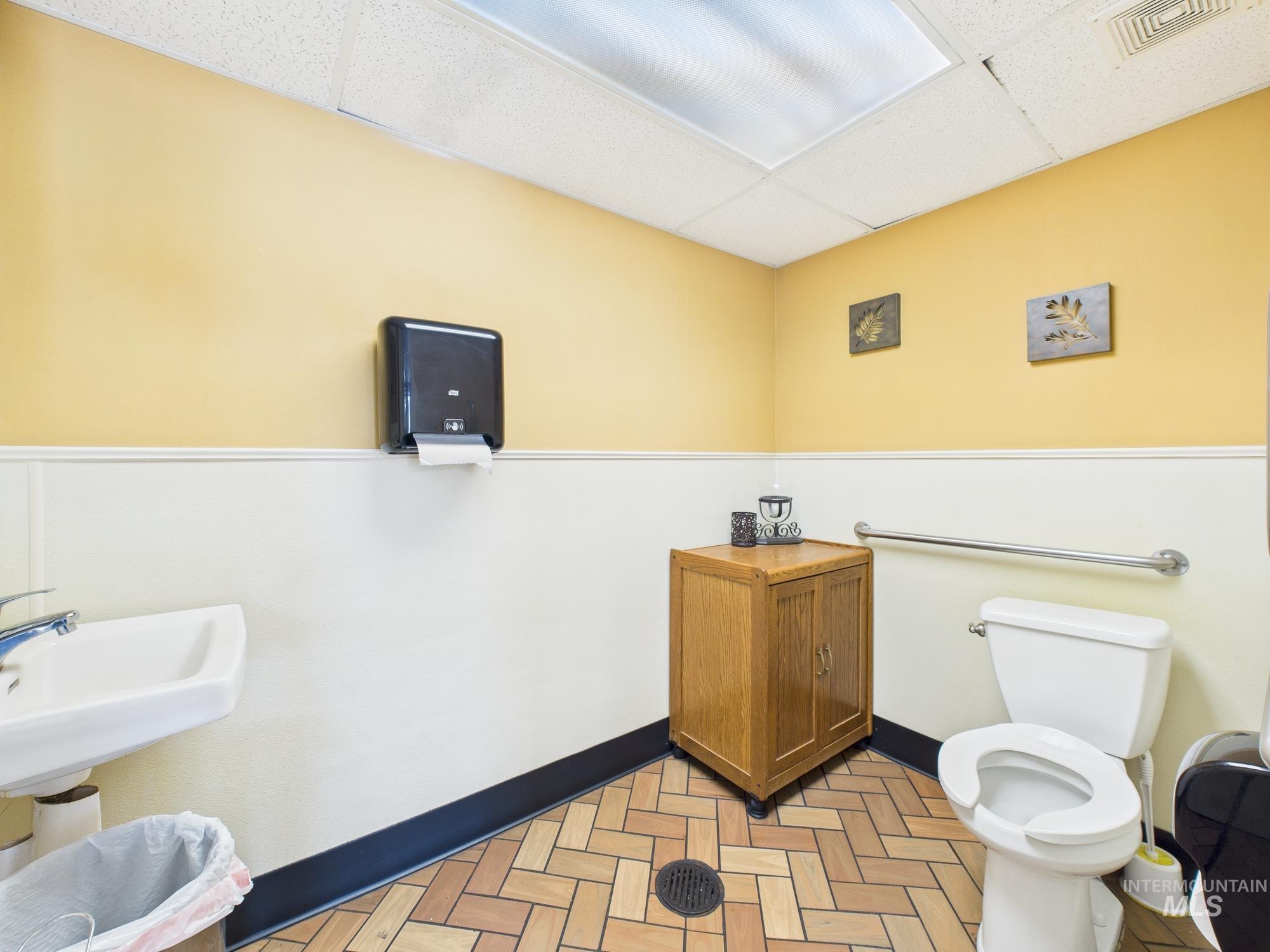 Bathroom with a drop ceiling and toilet