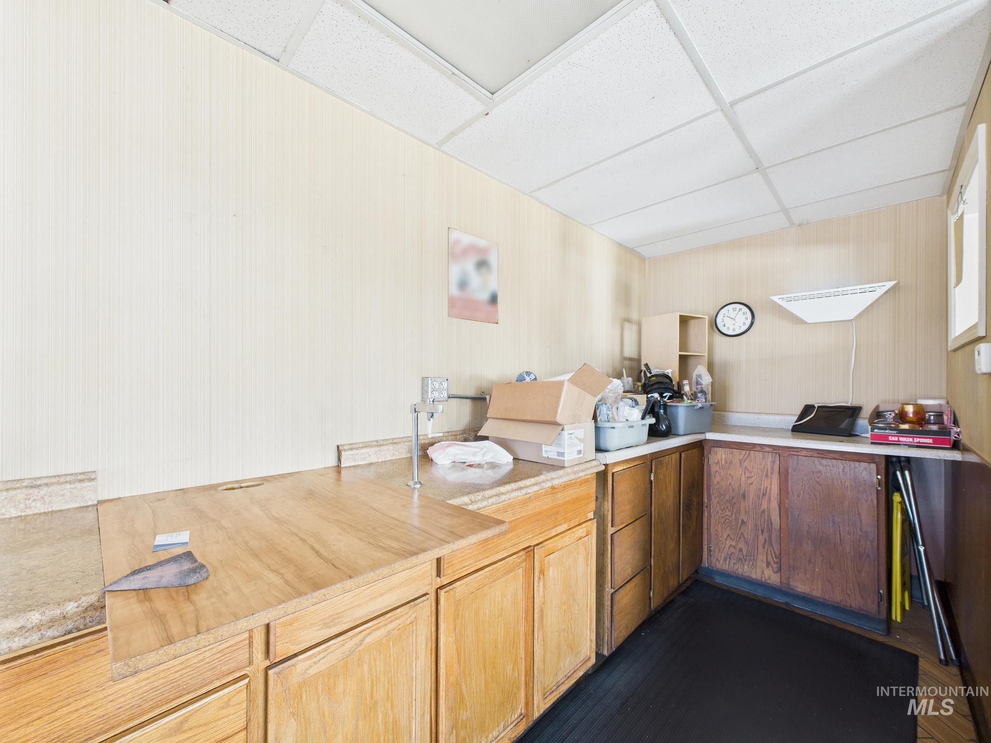 Kitchen with a drop ceiling and light countertops