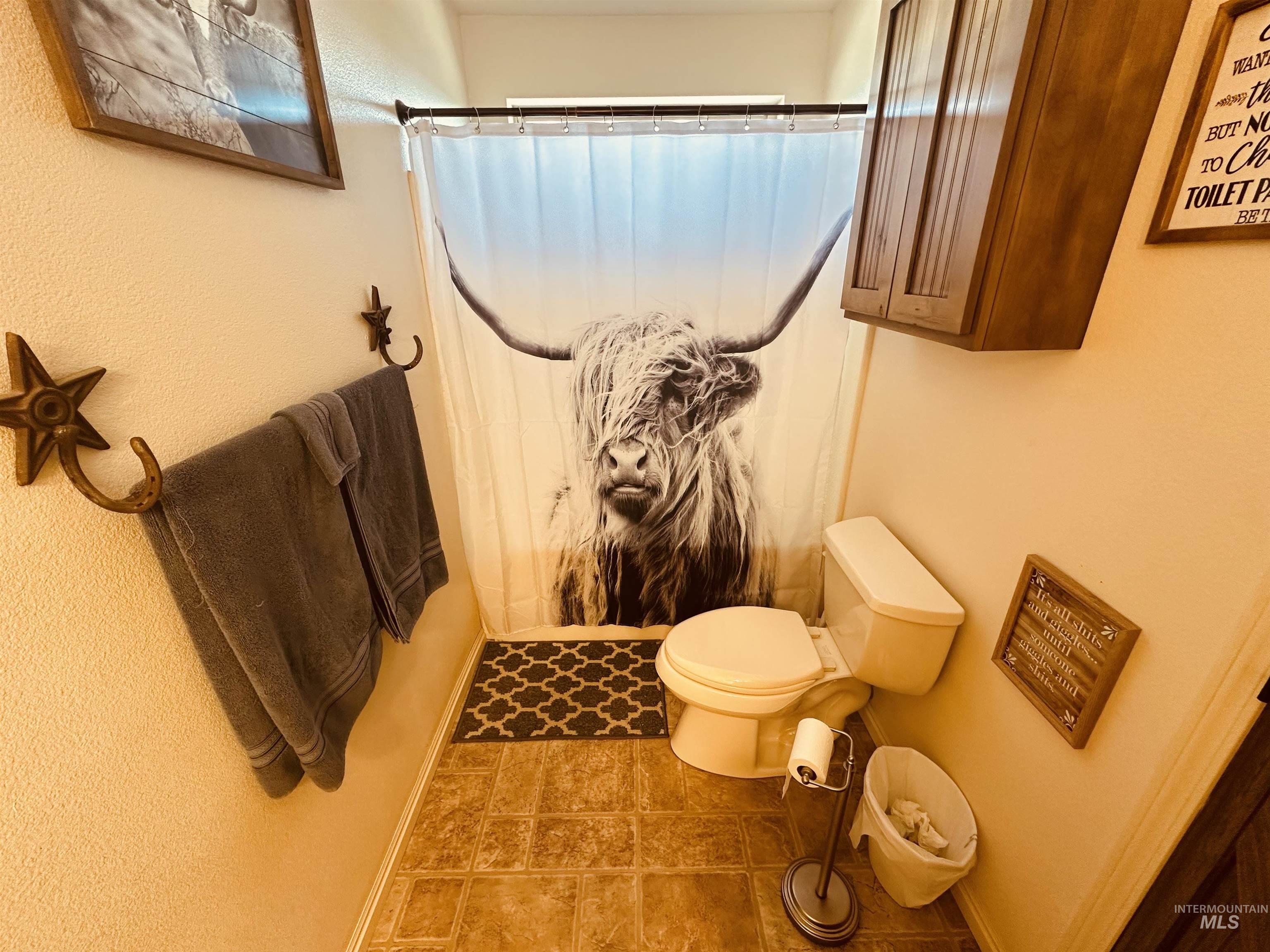 Full bathroom featuring a shower with curtain and a textured wall