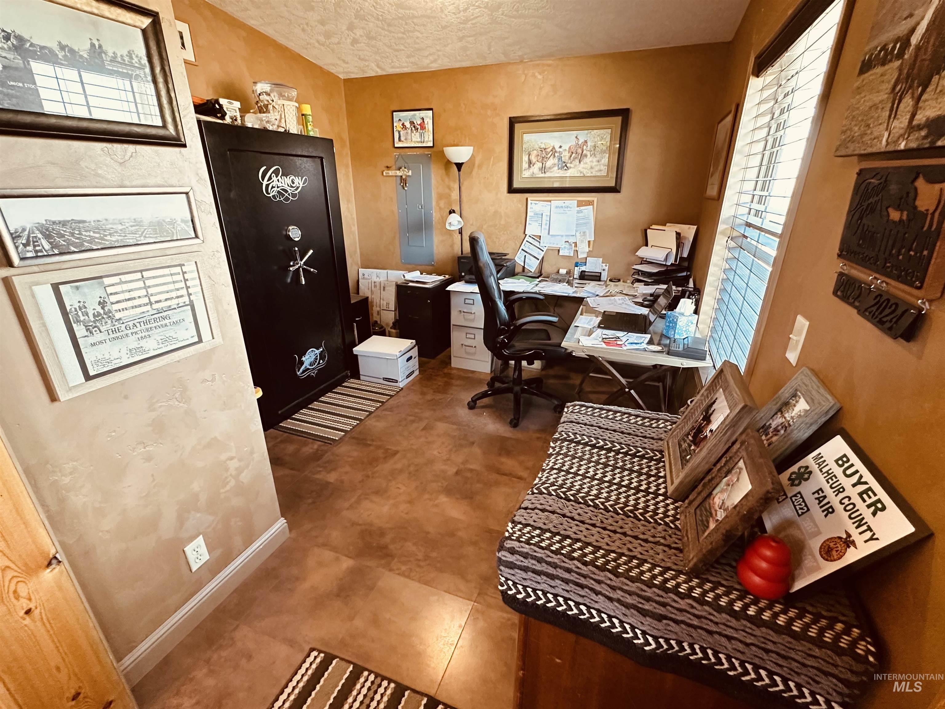 Office area with baseboards and a textured ceiling