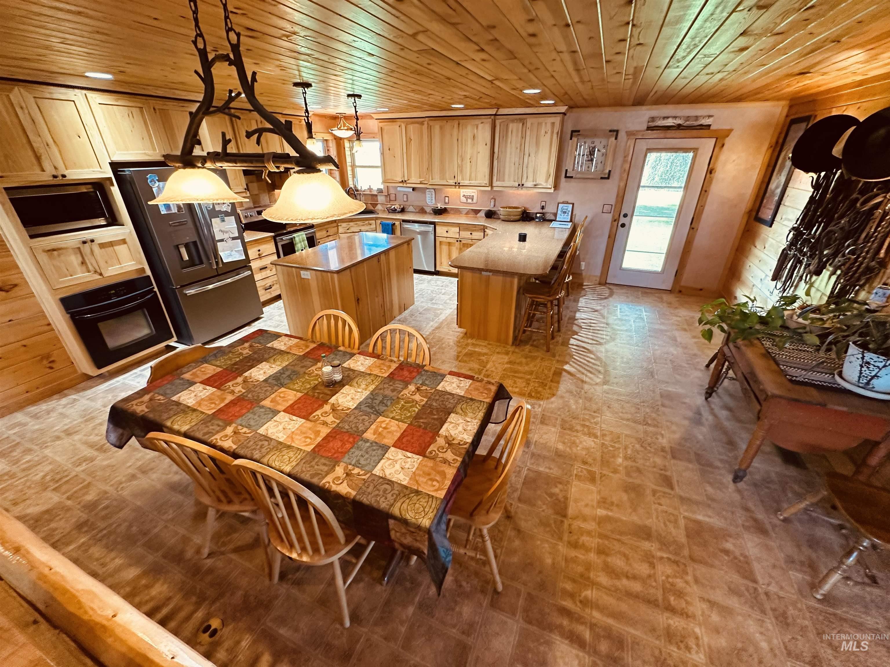 Dining space with wooden ceiling and recessed lighting