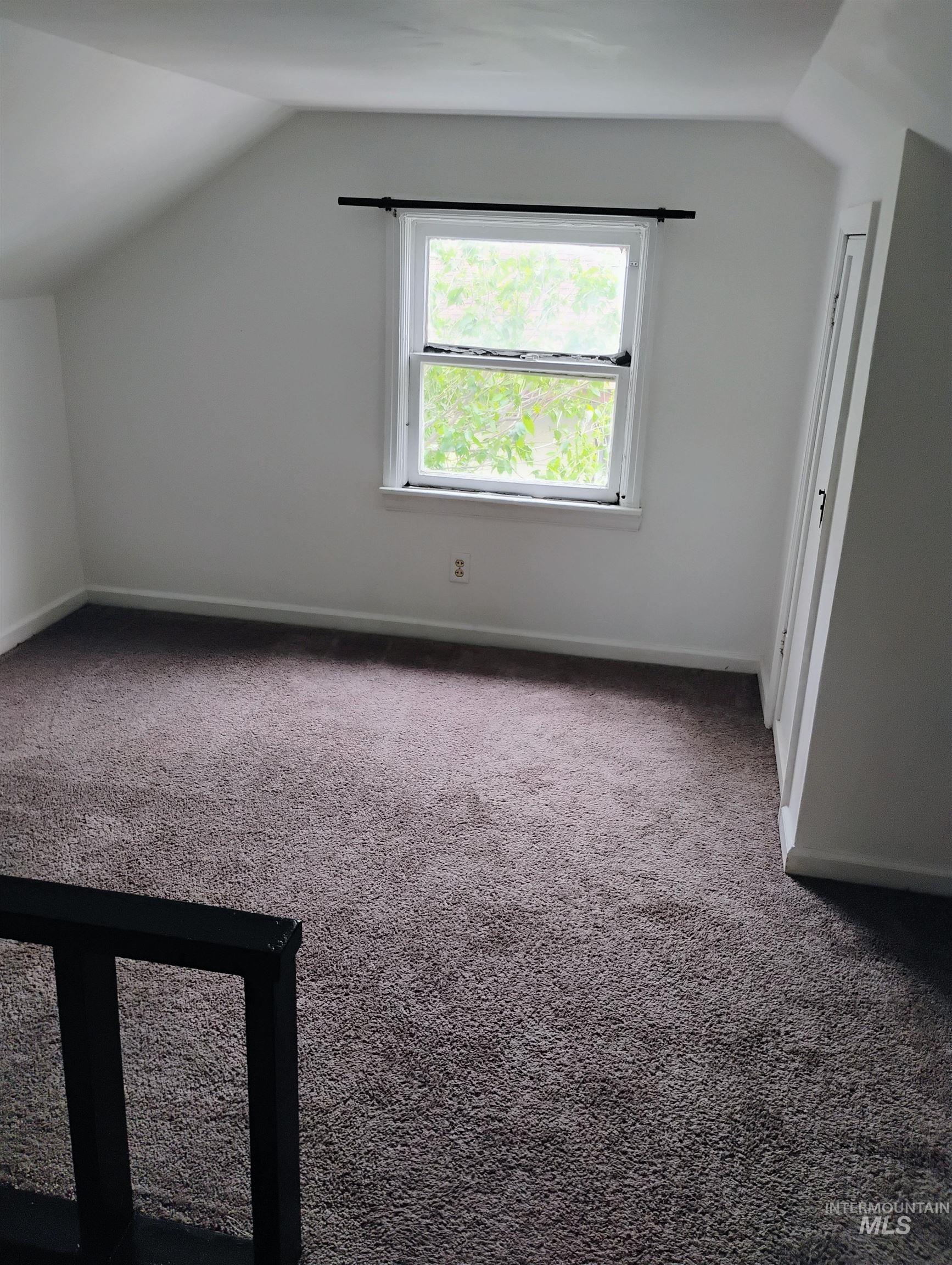 Bonus room with vaulted ceiling and carpet flooring