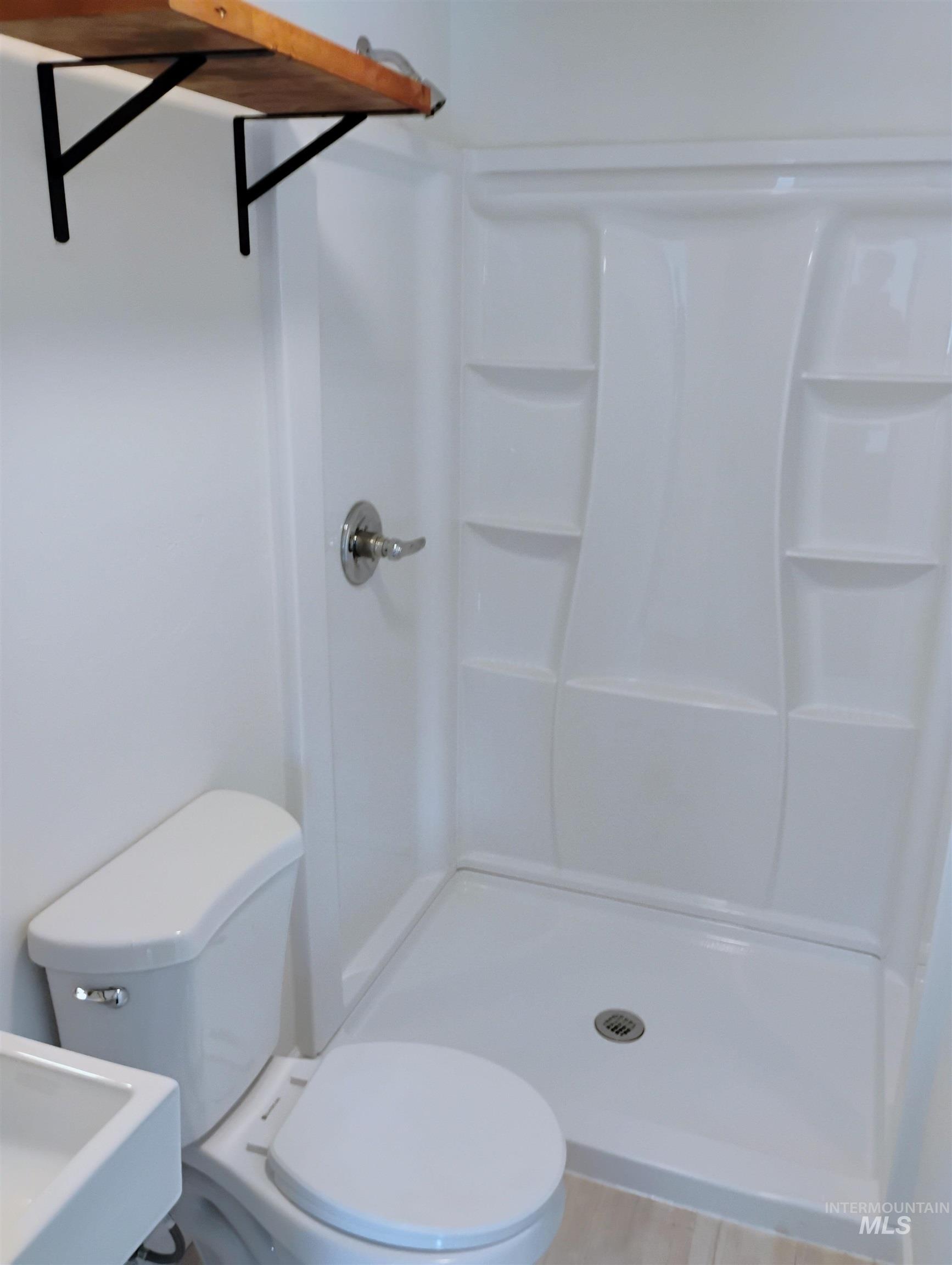 Full bathroom with a stall shower and toilet