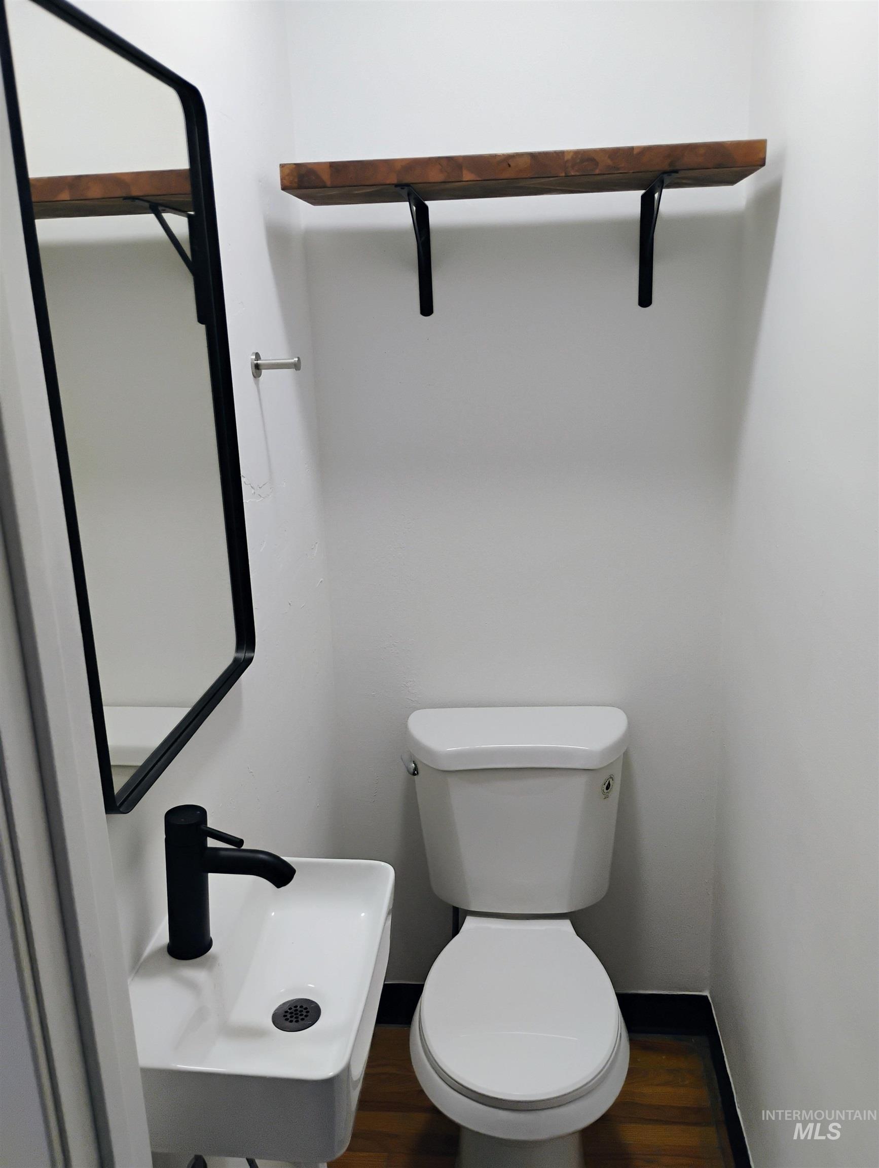 Bathroom featuring toilet and wood finished floors