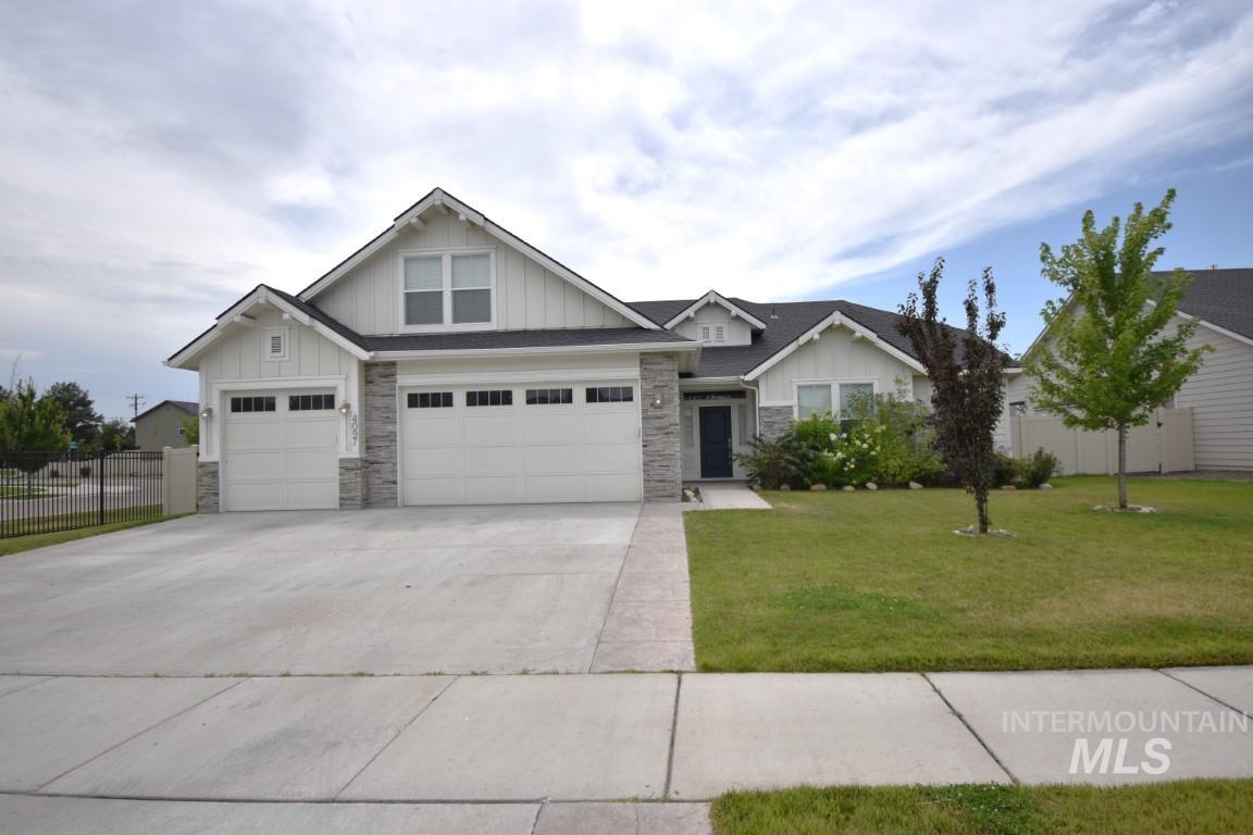 Craftsman inspired home with stone siding, concrete driveway, board and batten siding, and an attached garage
