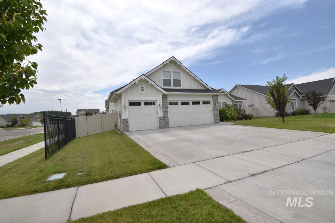 Craftsman-style home with board and batten siding, stone siding, driveway, and a garage