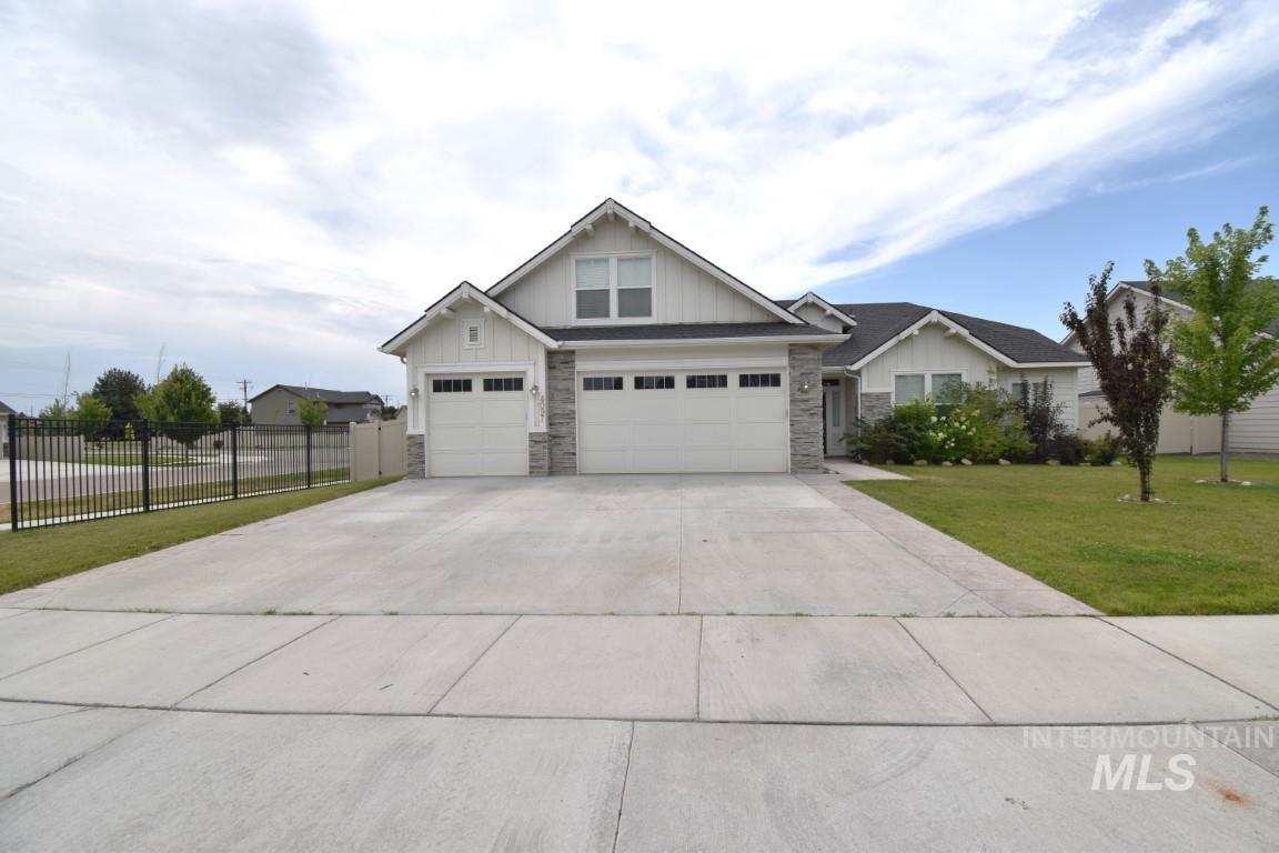 Craftsman inspired home featuring stone siding, board and batten siding, and concrete driveway