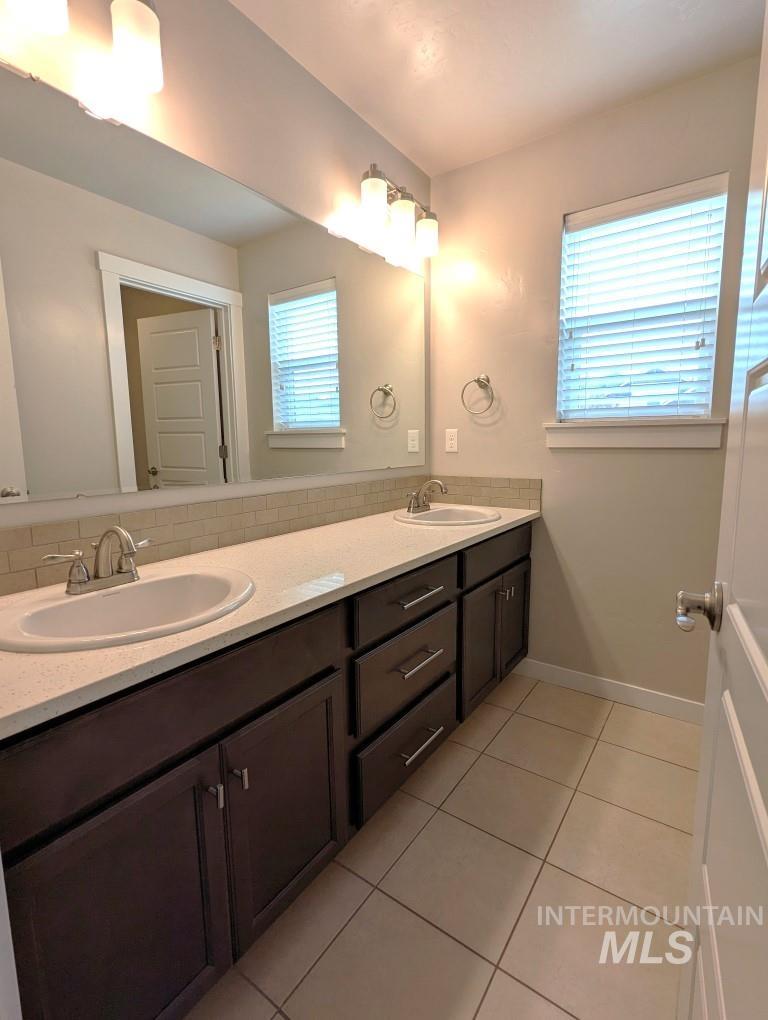 Bathroom featuring tile patterned floors and double vanity