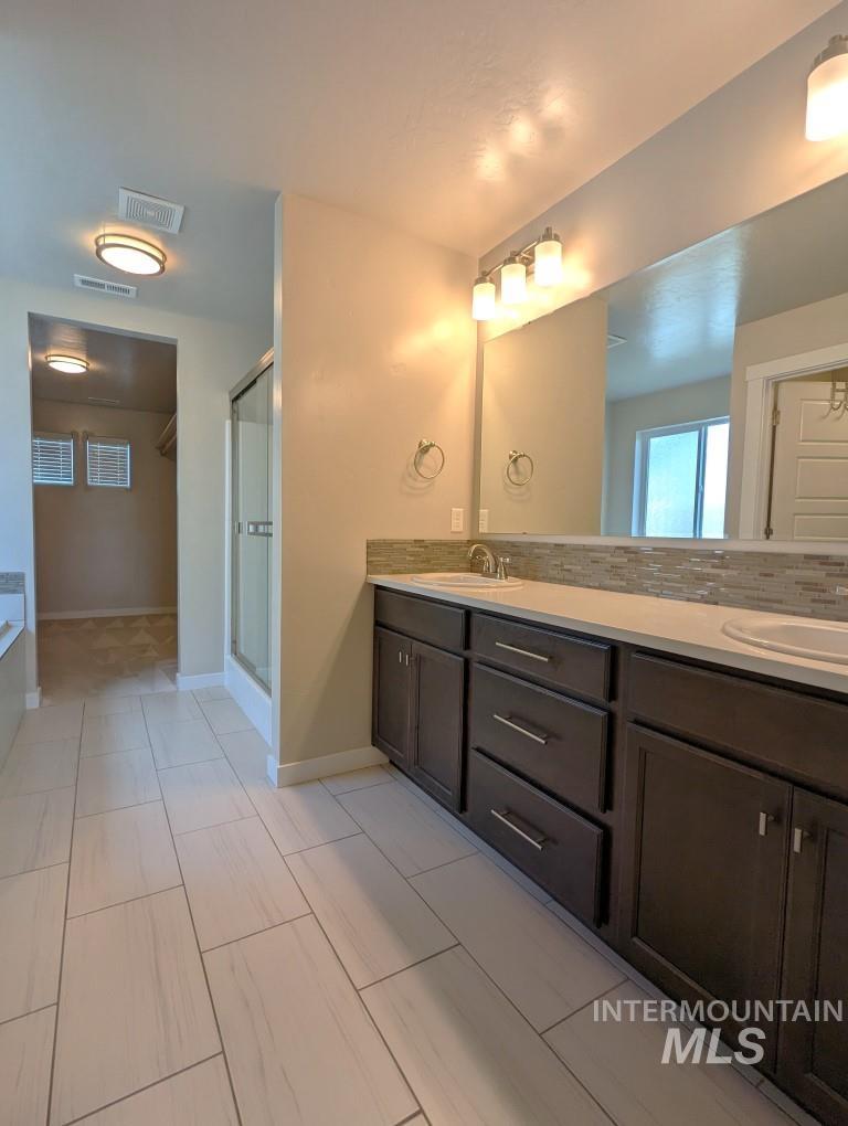 Bathroom with double vanity and a shower stall