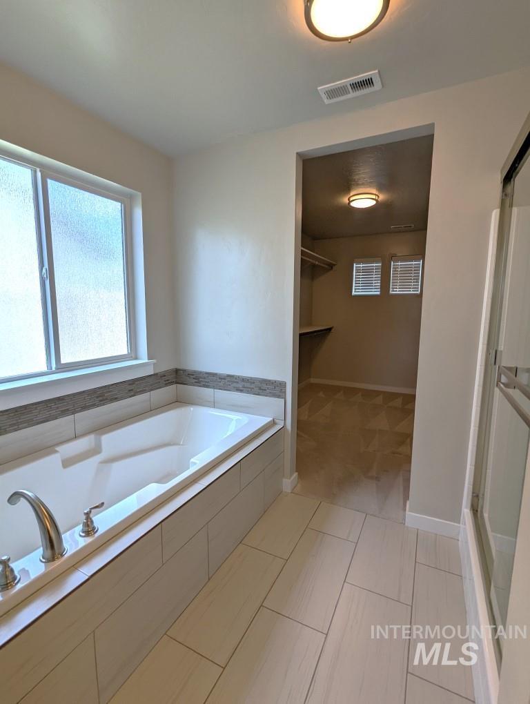 Full bath featuring a garden tub and a stall shower
