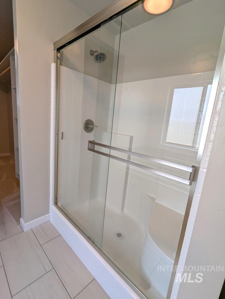 Bathroom with a stall shower and a spacious closet