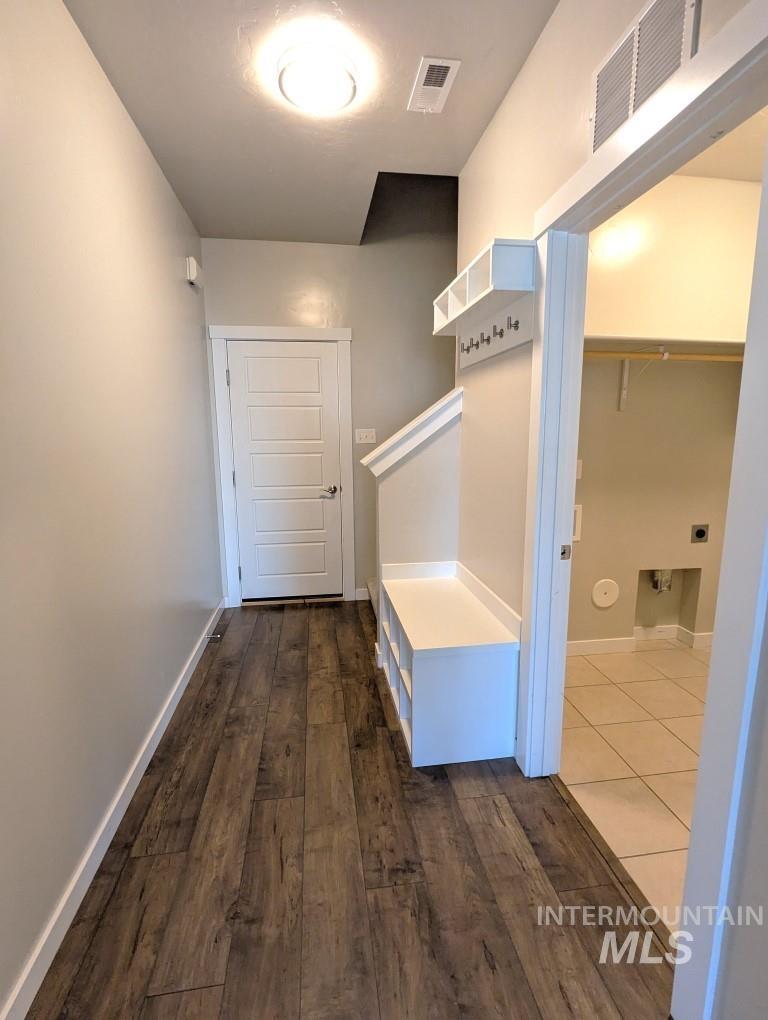 Mudroom featuring dark wood-style floors and baseboards