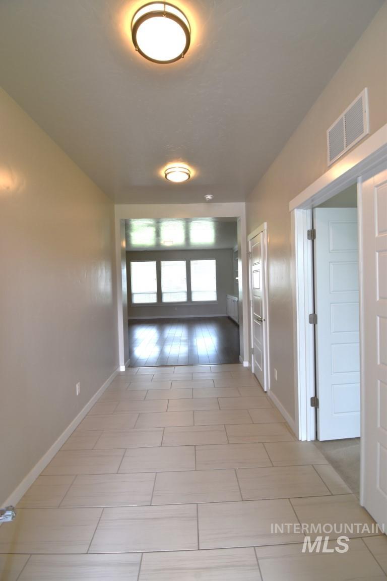 Corridor with baseboards and light tile patterned floors