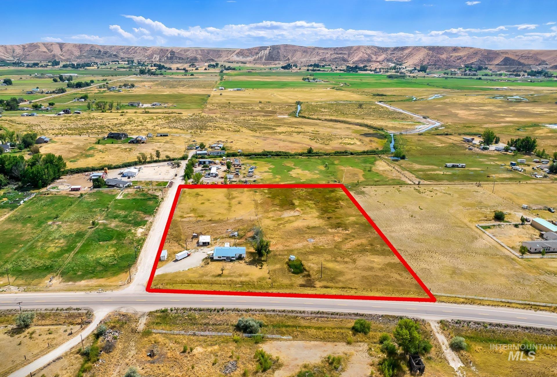 Aerial view of sparsely populated area featuring property boundaries highlighted and mountains