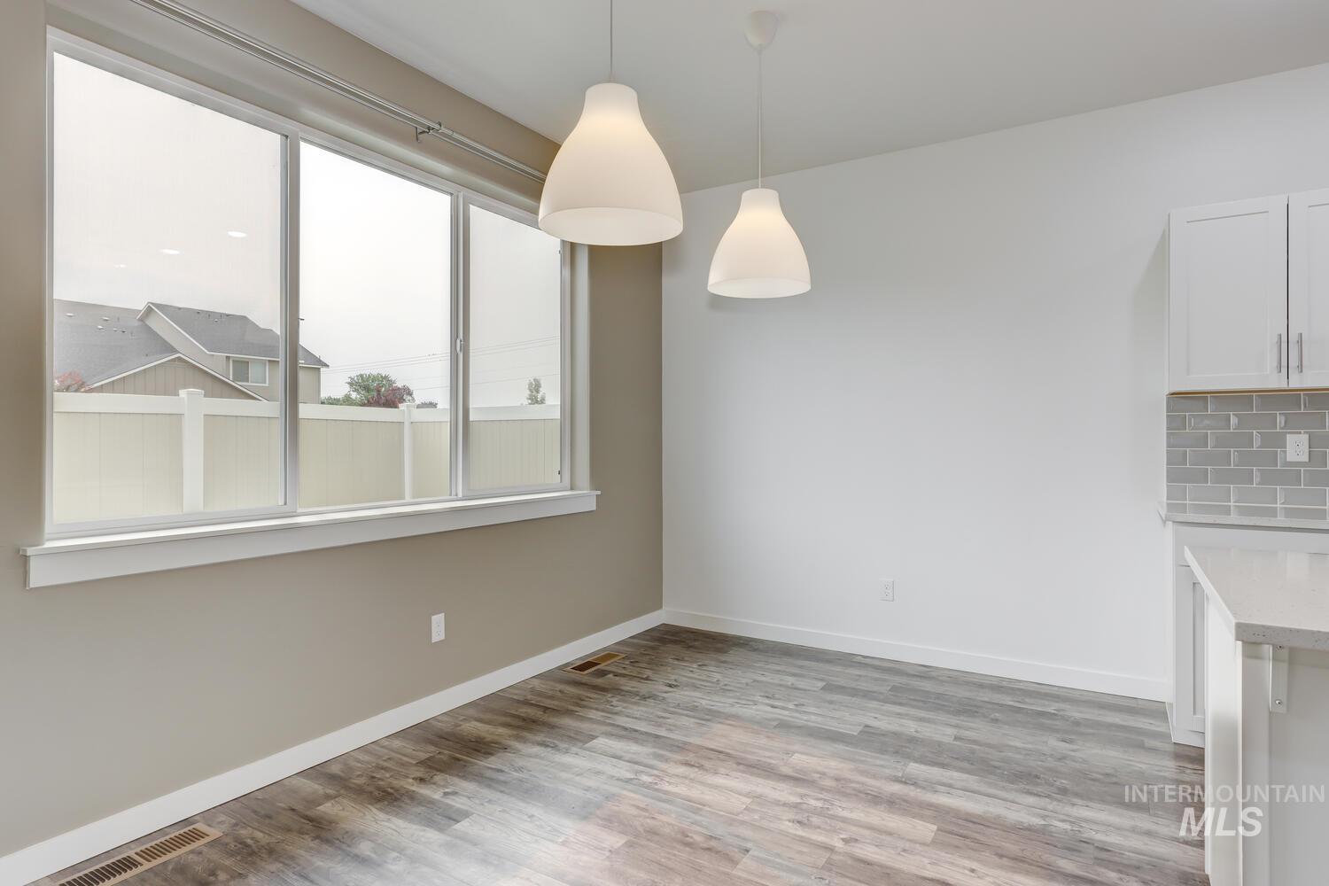 Unfurnished dining area with light wood-style flooring and baseboards