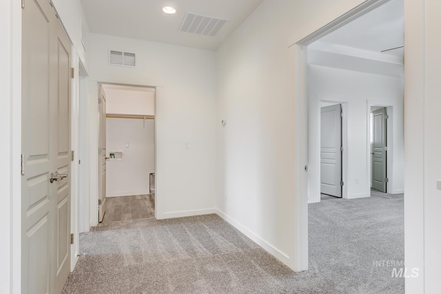 Hallway featuring light colored carpet and recessed lighting
