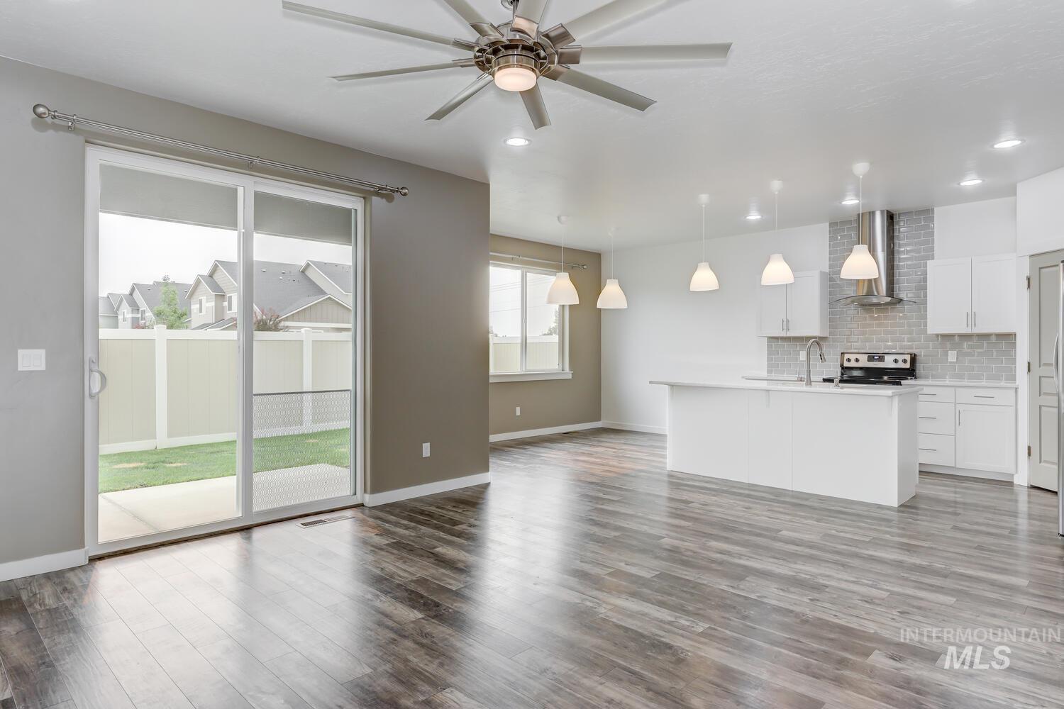 Unfurnished living room featuring wood finished floors, ceiling fan, and recessed lighting