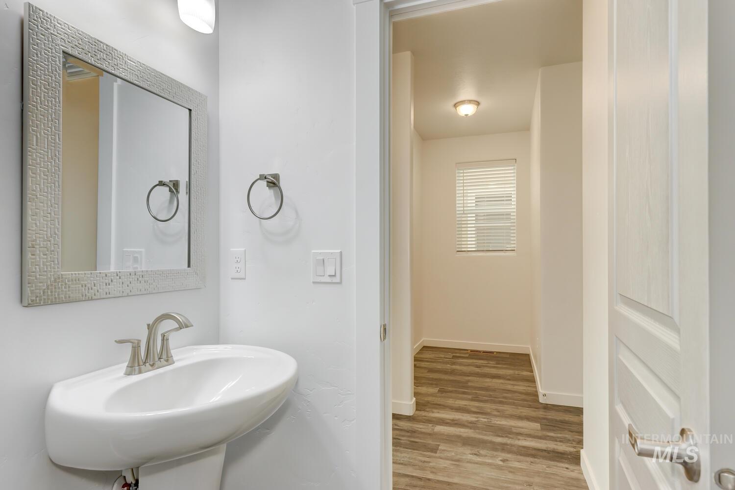 Bathroom with wood finished floors and baseboards