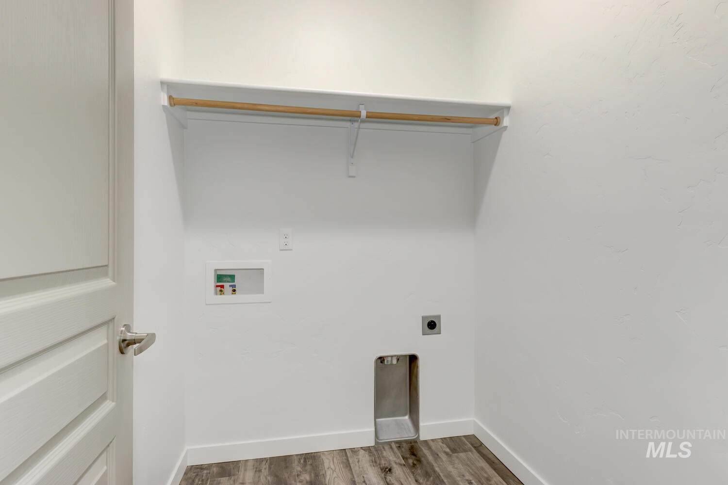 Washroom with hookup for an electric dryer, washer hookup, and dark wood-type flooring