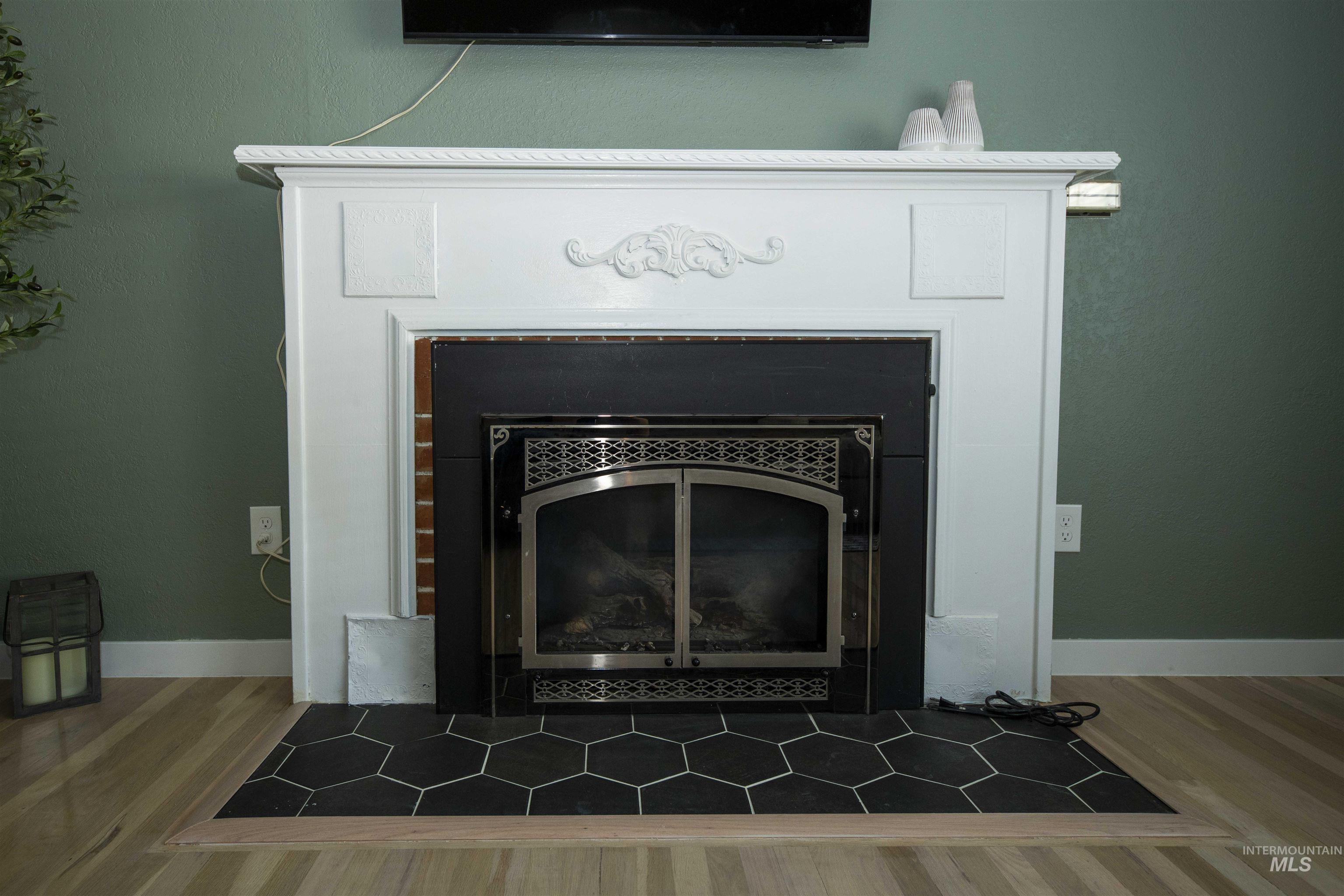 Detailed view of wood finished floors and a tiled fireplace