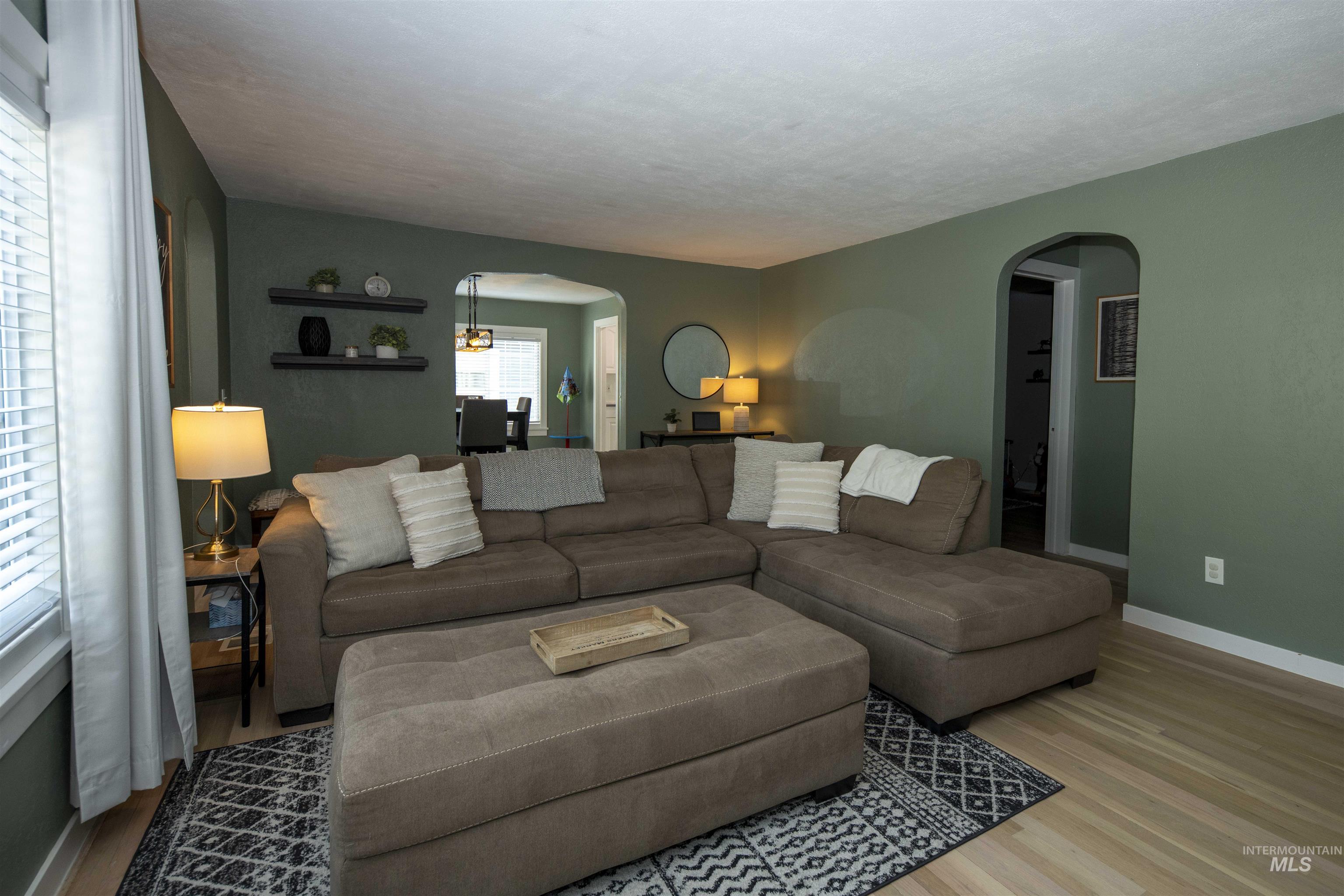 Living area with wood finished floors and arched walkways