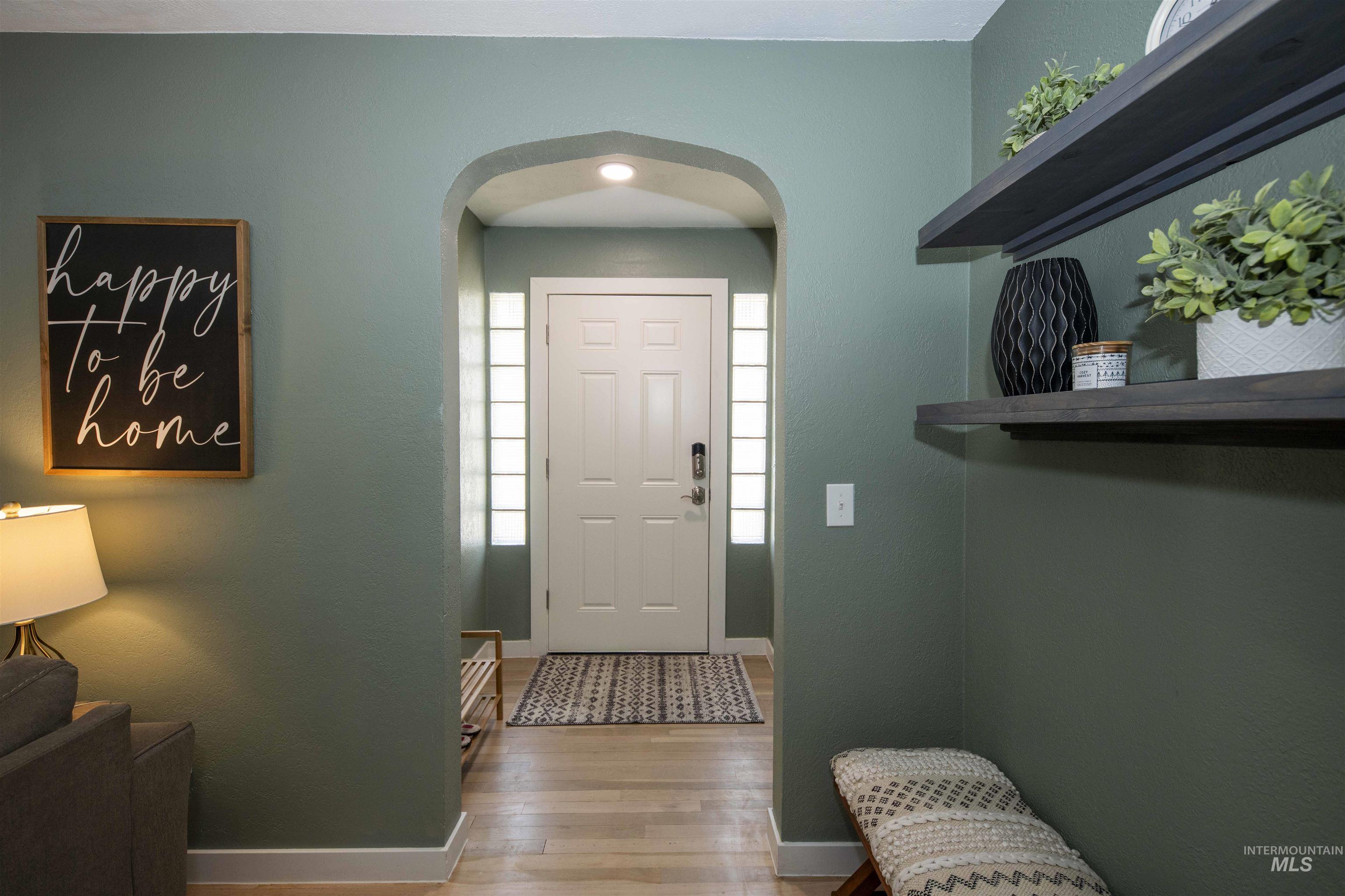 Entrance foyer with wood finished floors and arched walkways