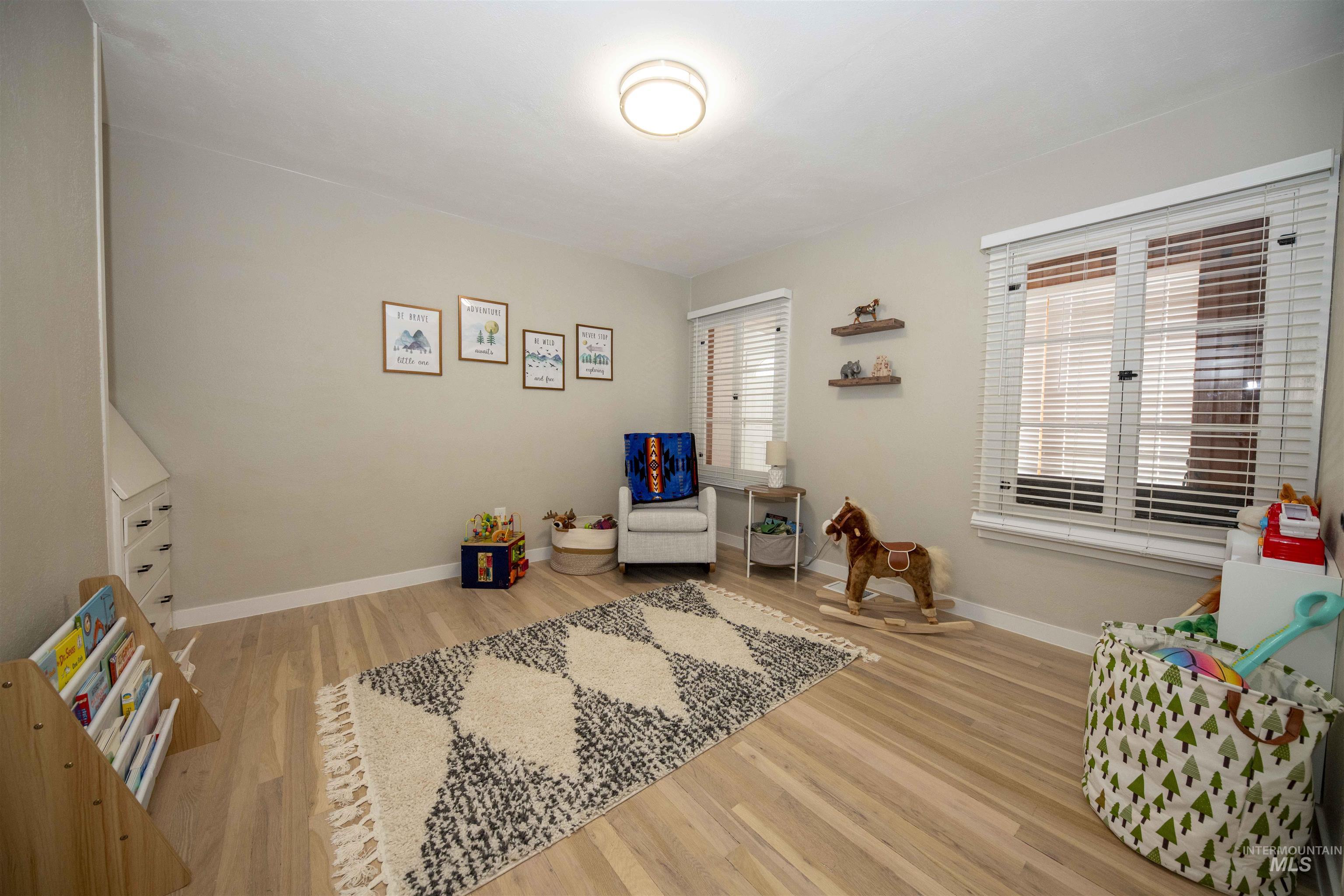 Bedroom on ground level in the main house with wood finished floors and baseboards