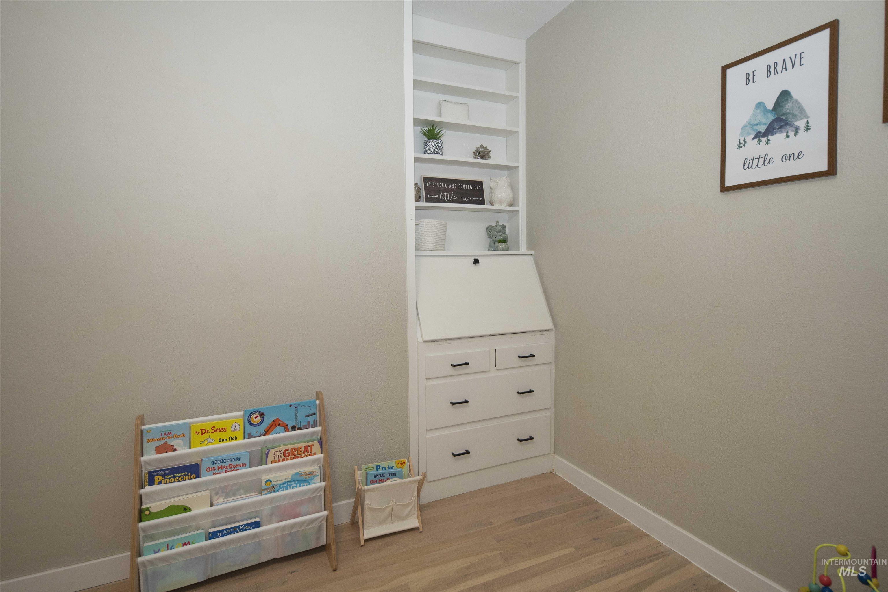 Bedroom on ground level in main house with light wood finished floors and built in features
