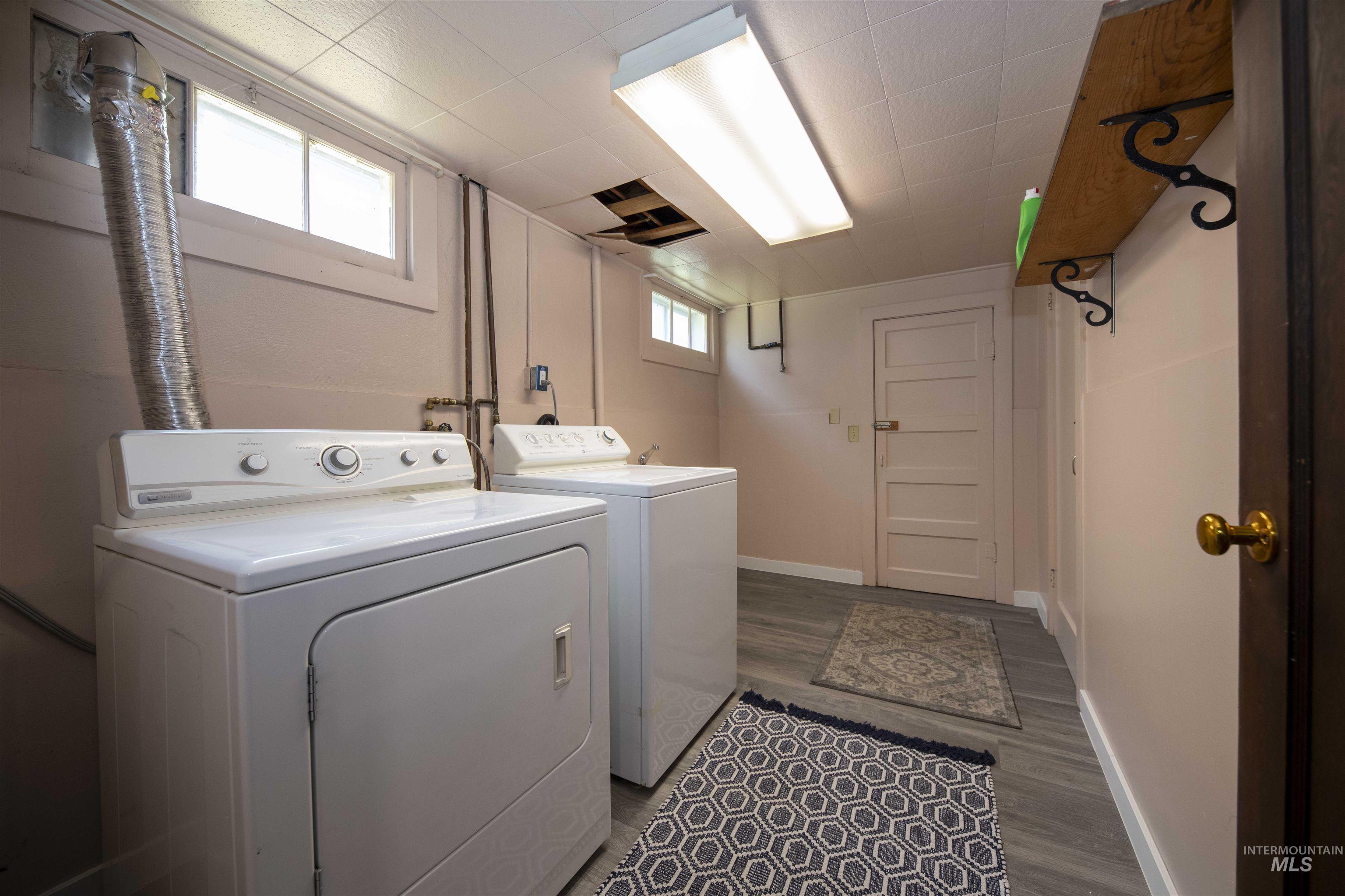 Laundry room with washing machine and dryer and dark wood-type flooring