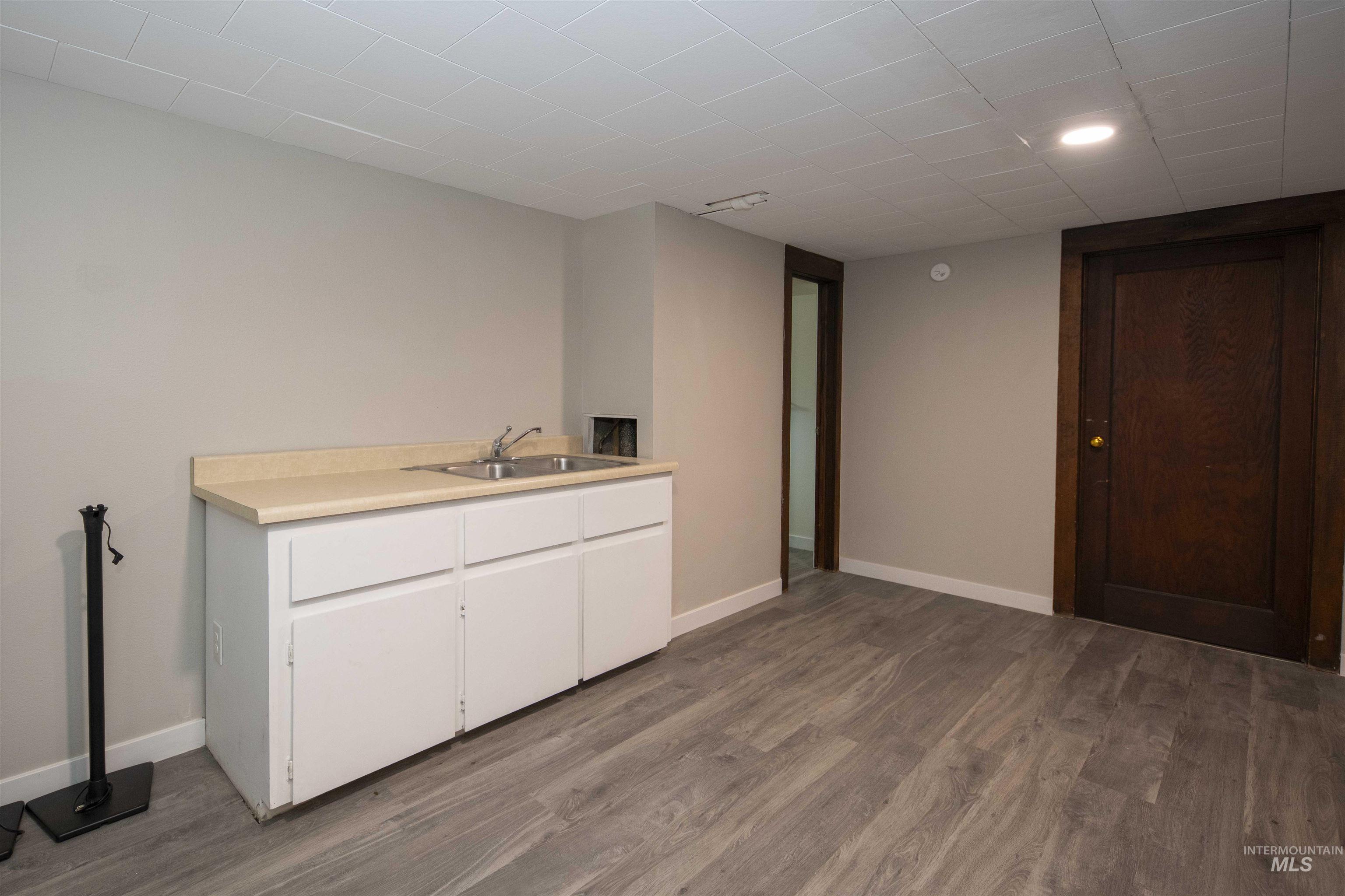 Sink in basement featuring wood finished floors and recessed lighting