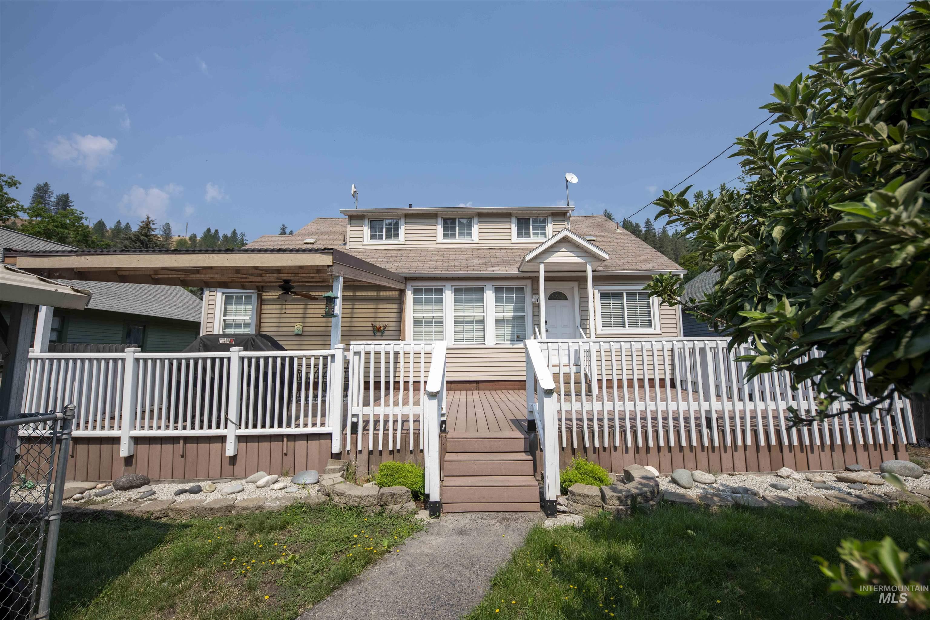 Bungalow-style house with a shingled roof, ceiling fan, and a deck