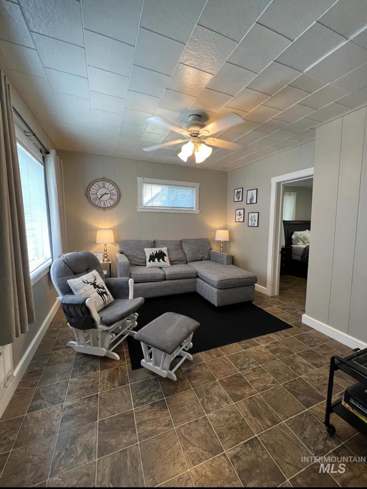 2nd home / AirBNB - Living area featuring ceiling fan and stone finish flooring
