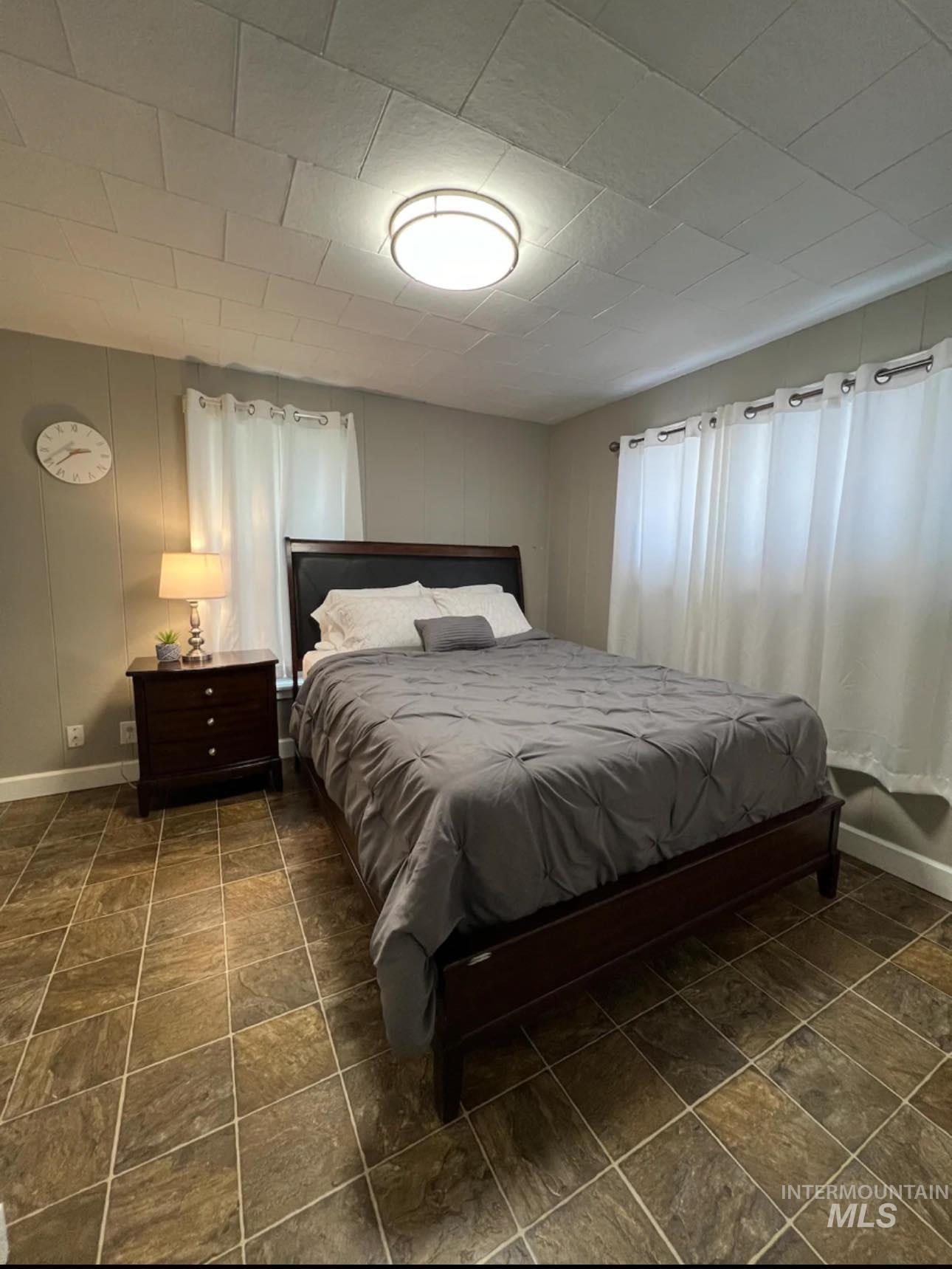 2nd home / AirBNB - Bedroom featuring baseboards and stone finish floors