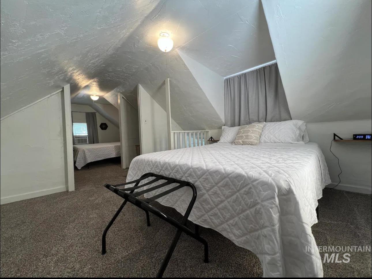 2nd home / AirBNB - Carpeted bedroom with lofted ceiling and baseboards