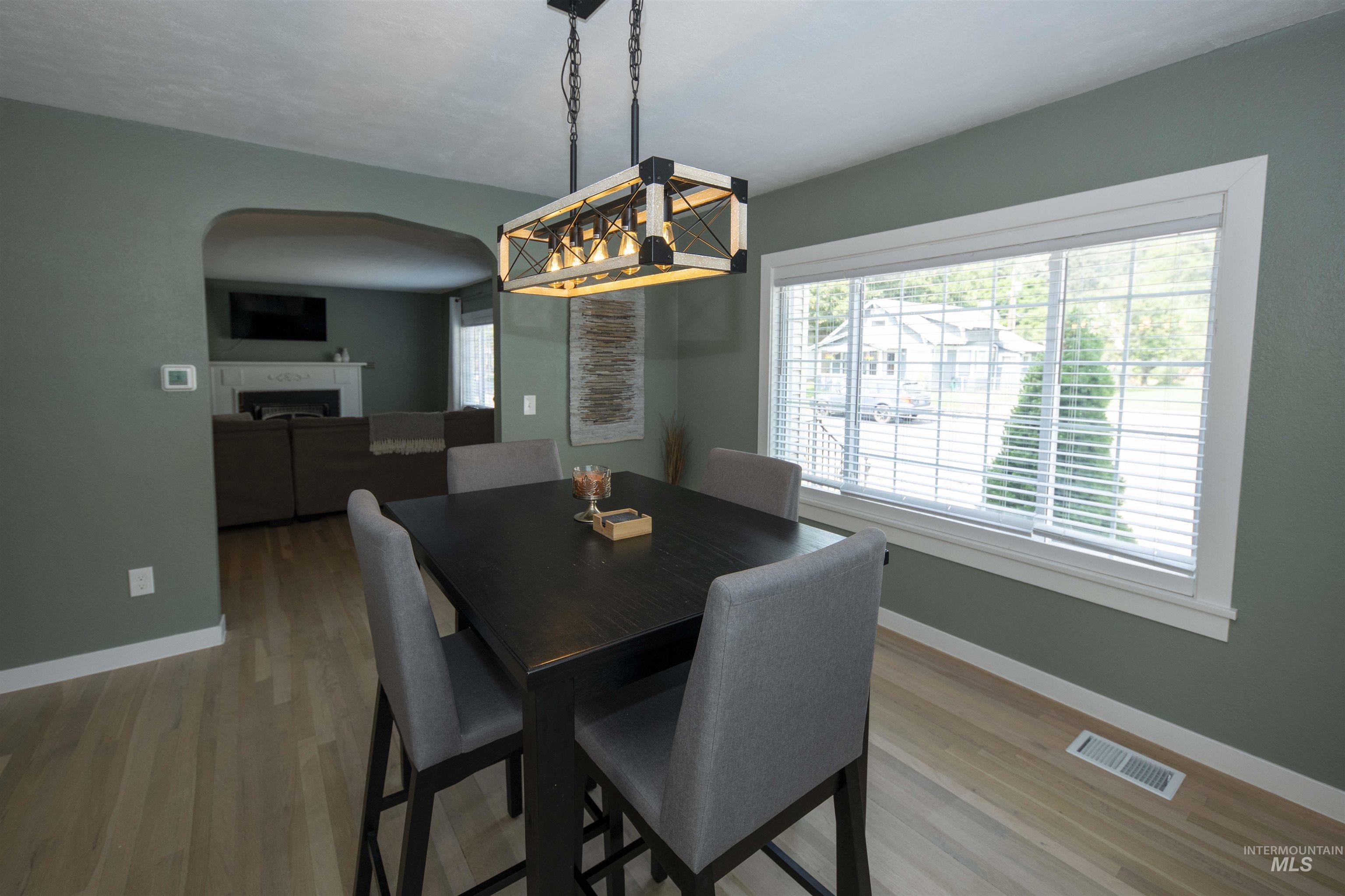 Dining space featuring a fireplace, plenty of natural light, and wood finished floors