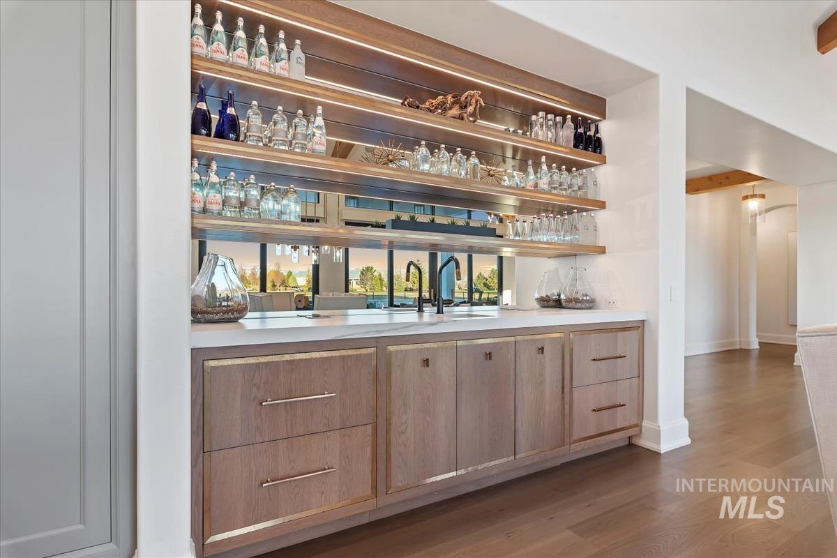 Indoor wet bar featuring wood finished floors and baseboards