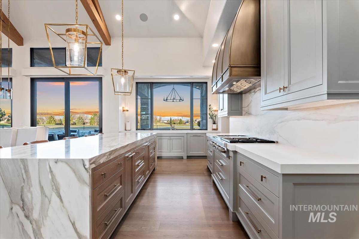 Kitchen with recessed lighting, premium range hood, light stone countertops, dark wood-type flooring, and a kitchen island