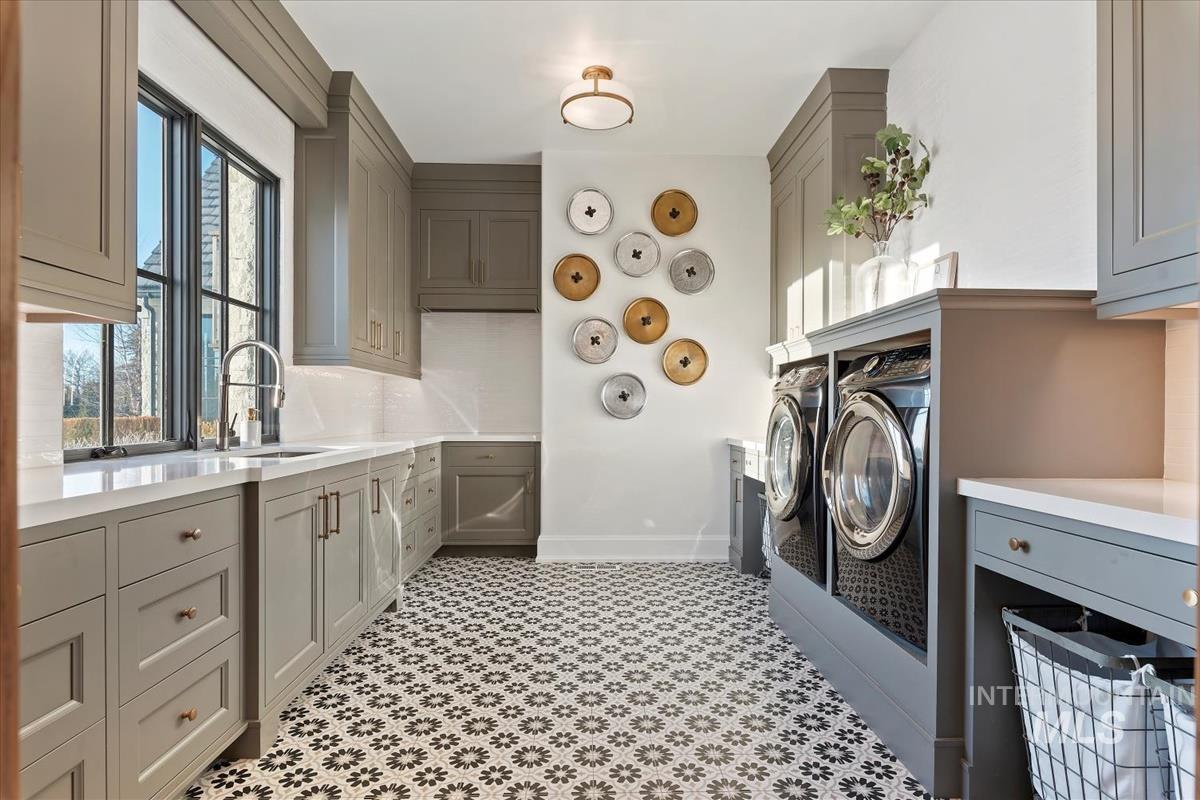 Laundry room with washing machine and dryer, cabinet space, and light flooring