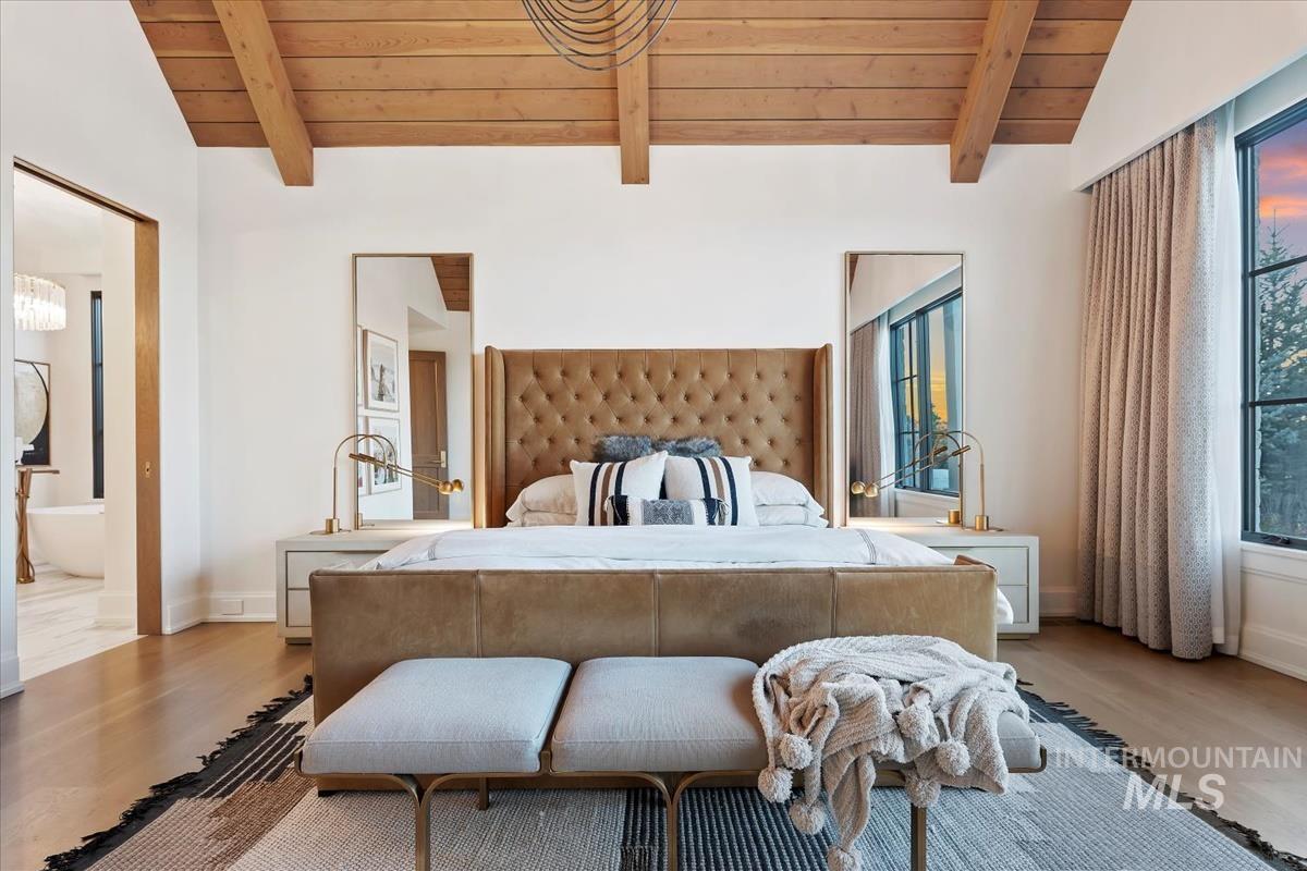 Bedroom featuring wood ceiling, wood finished floors, and ensuite bath