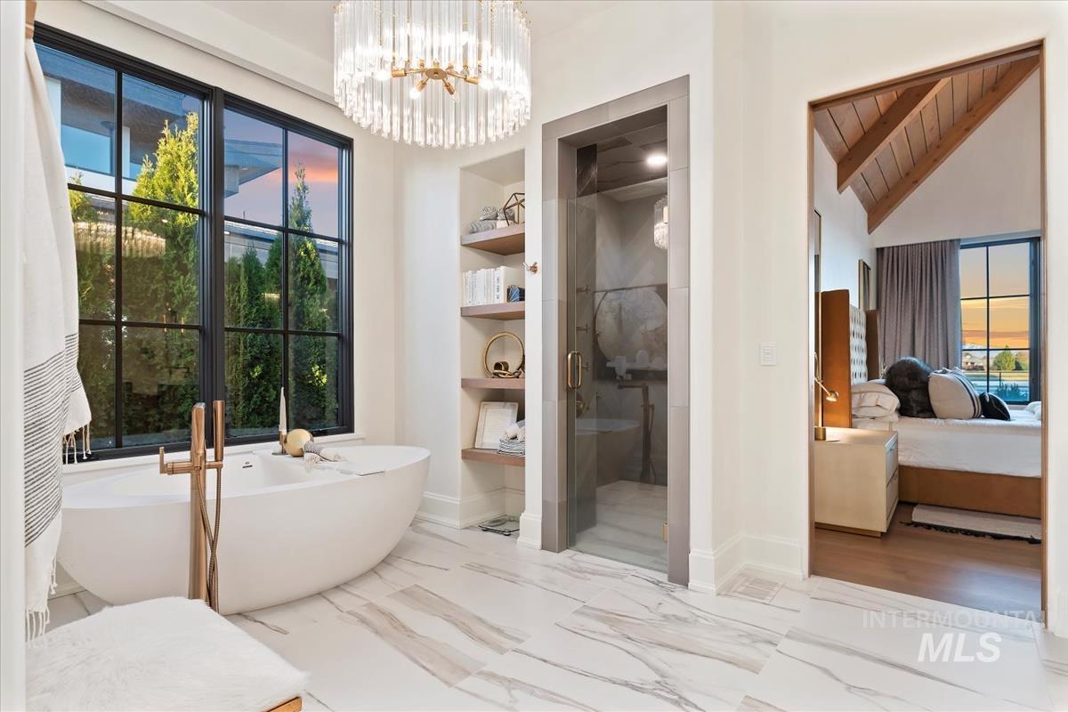 Bathroom with ensuite bath, plenty of natural light, a stall shower, marble finish floors, and vaulted ceiling