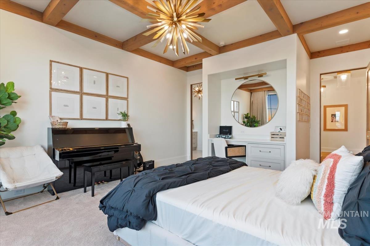 Carpeted bedroom featuring beamed ceiling, coffered ceiling, and a chandelier