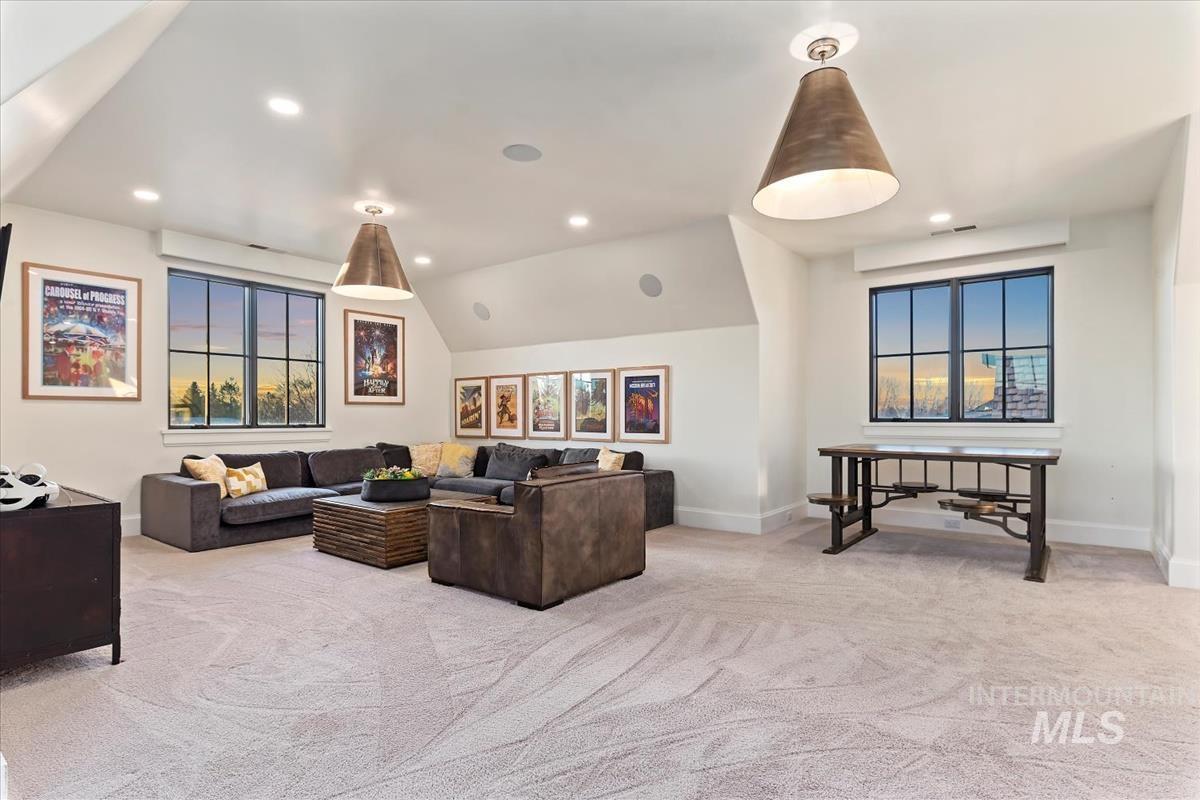 Carpeted living room featuring plenty of natural light, recessed lighting, and lofted ceiling