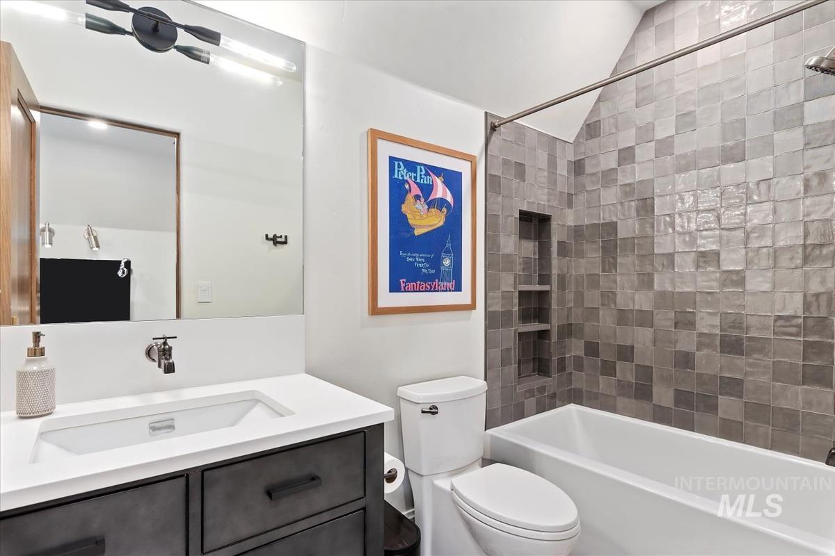 Bathroom featuring lofted ceiling, vanity, and shower / bath combination