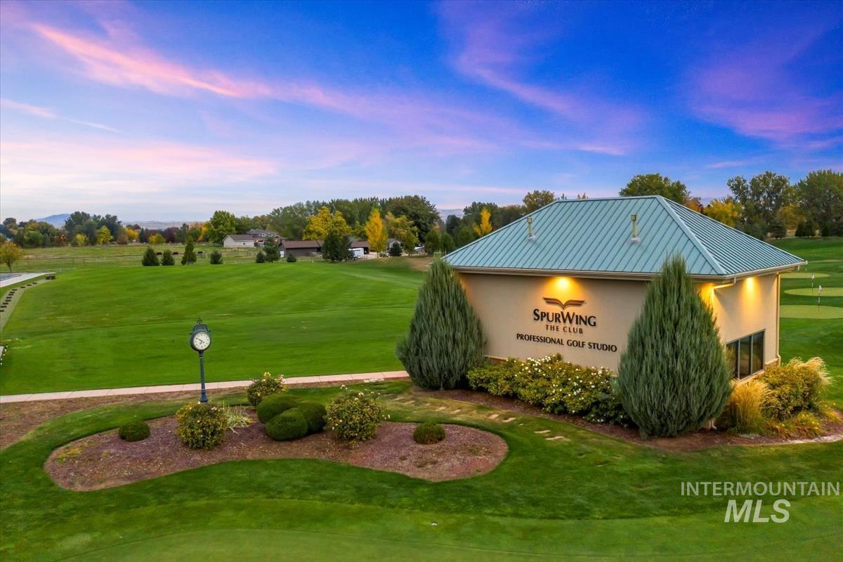 Community sign with a yard and golf course view