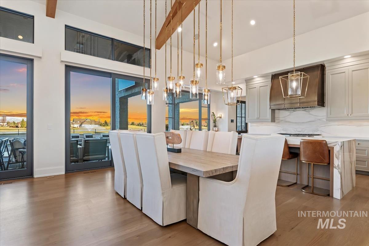 Dining area with wood finished floors, a chandelier, and recessed lighting
