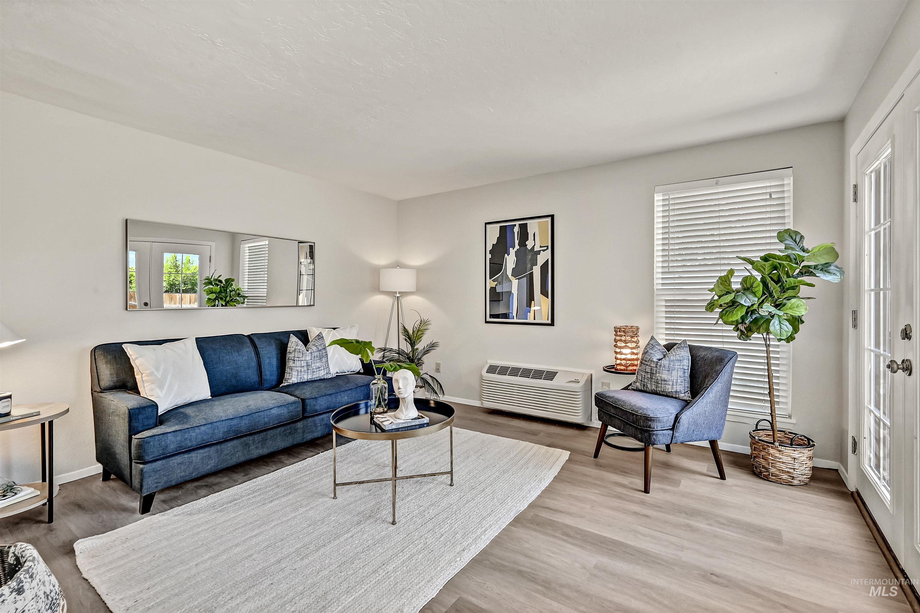 Unit A: Living room featuring LVP flooring and an AC wall unit