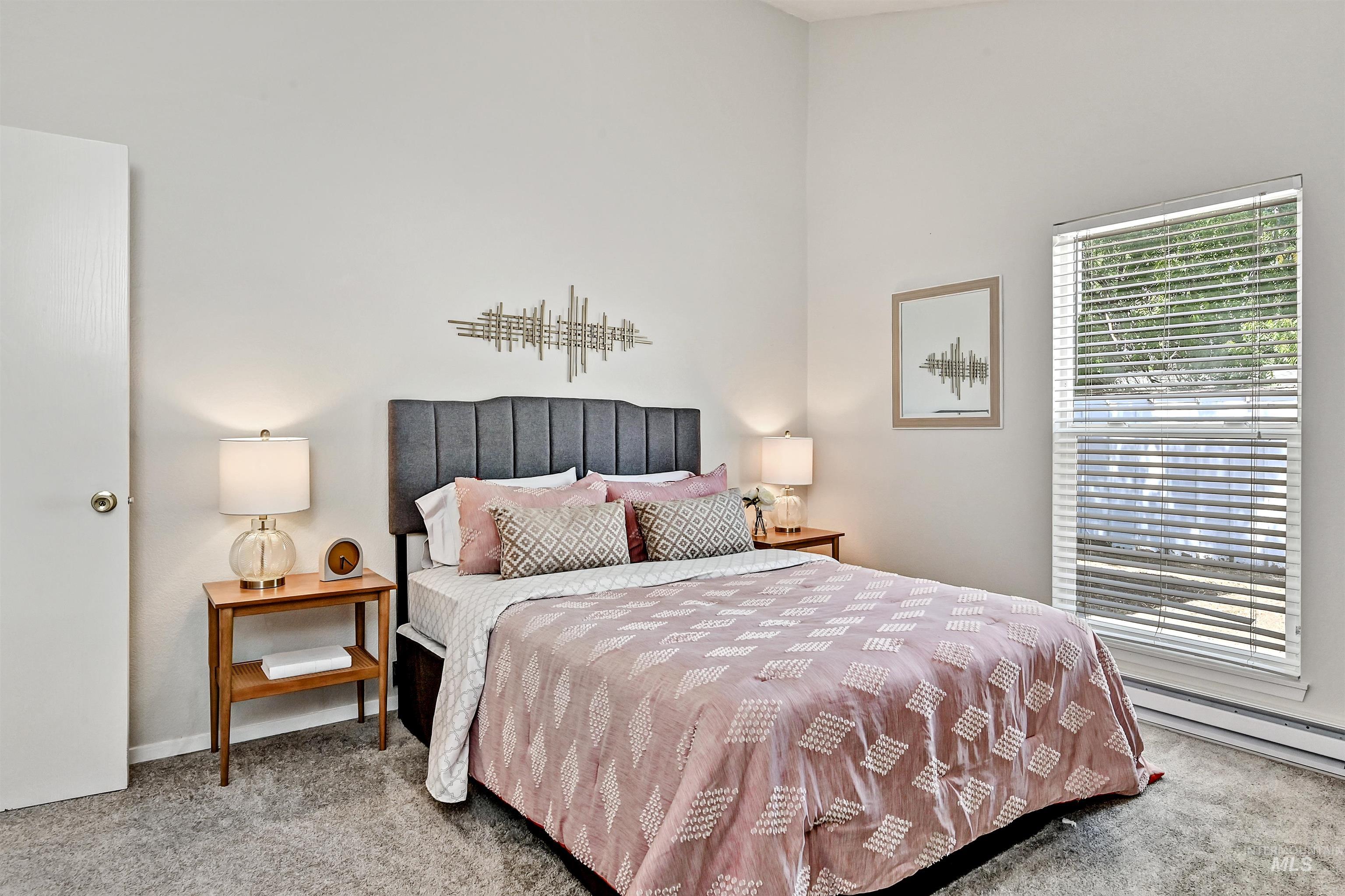 Unit A: Bedroom 1 with carpet and a baseboard heating unit