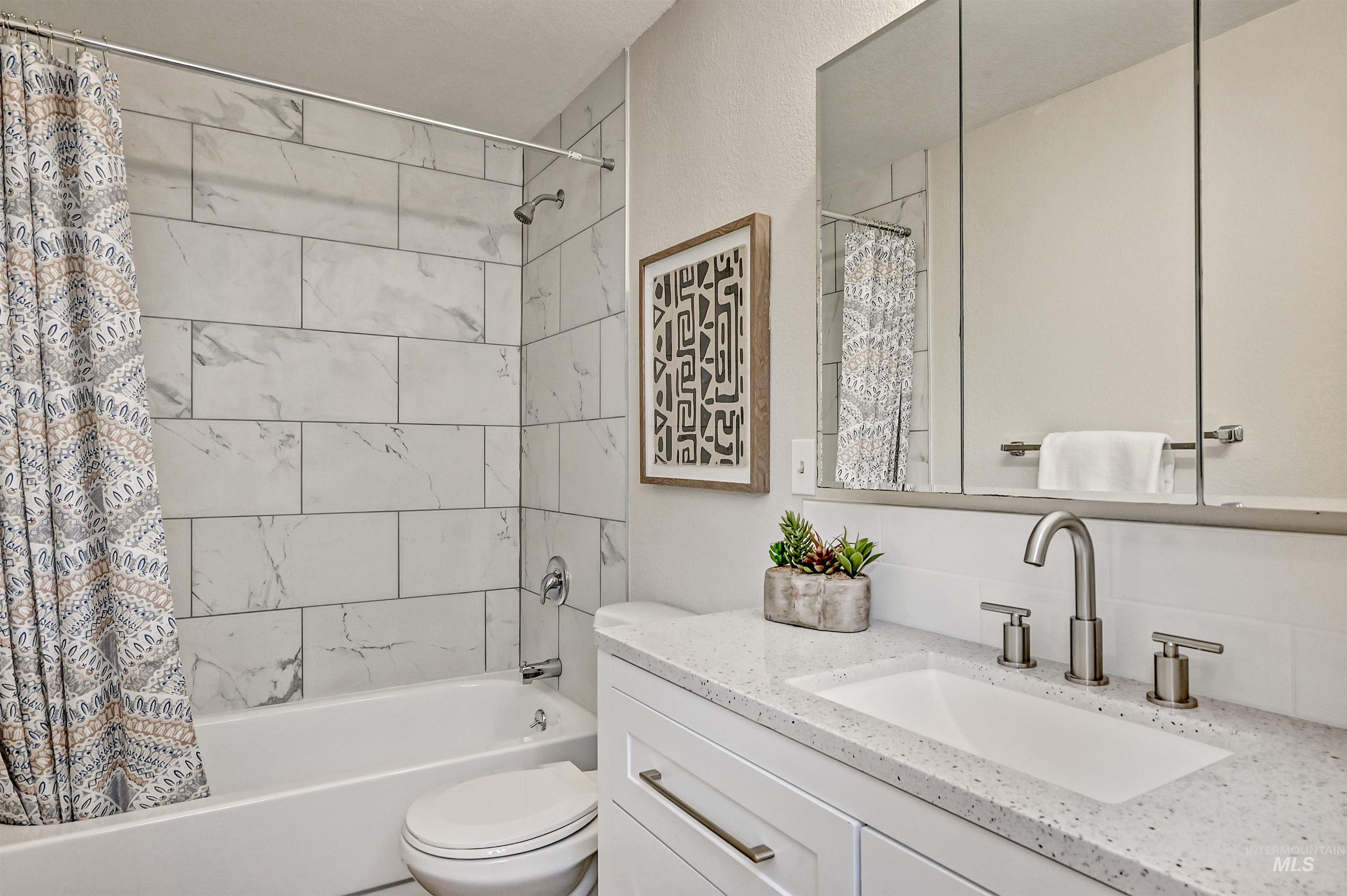 Unit A: Bathroom 1 featuring shower / bathtub combination and vanity