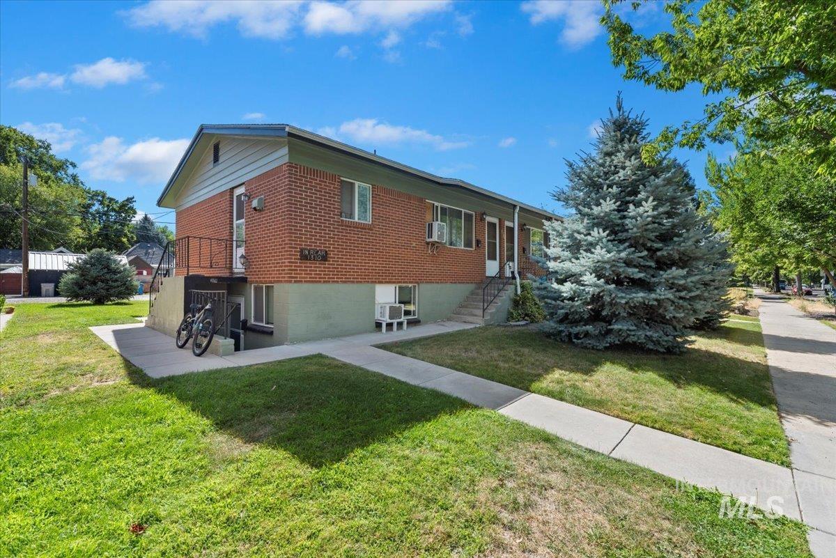 View of home's exterior with brick siding, a yard, and a patio